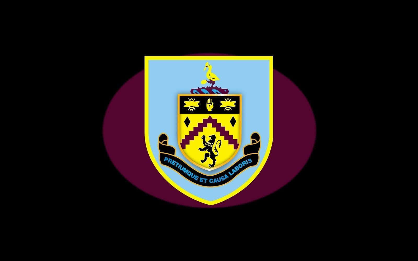 Burnley Fc 桌布 壁紙 — 一個充滿活力的會徽，在黑色背景上的栗色橢圓形上有一個帶有黃色獅子的盾牌。