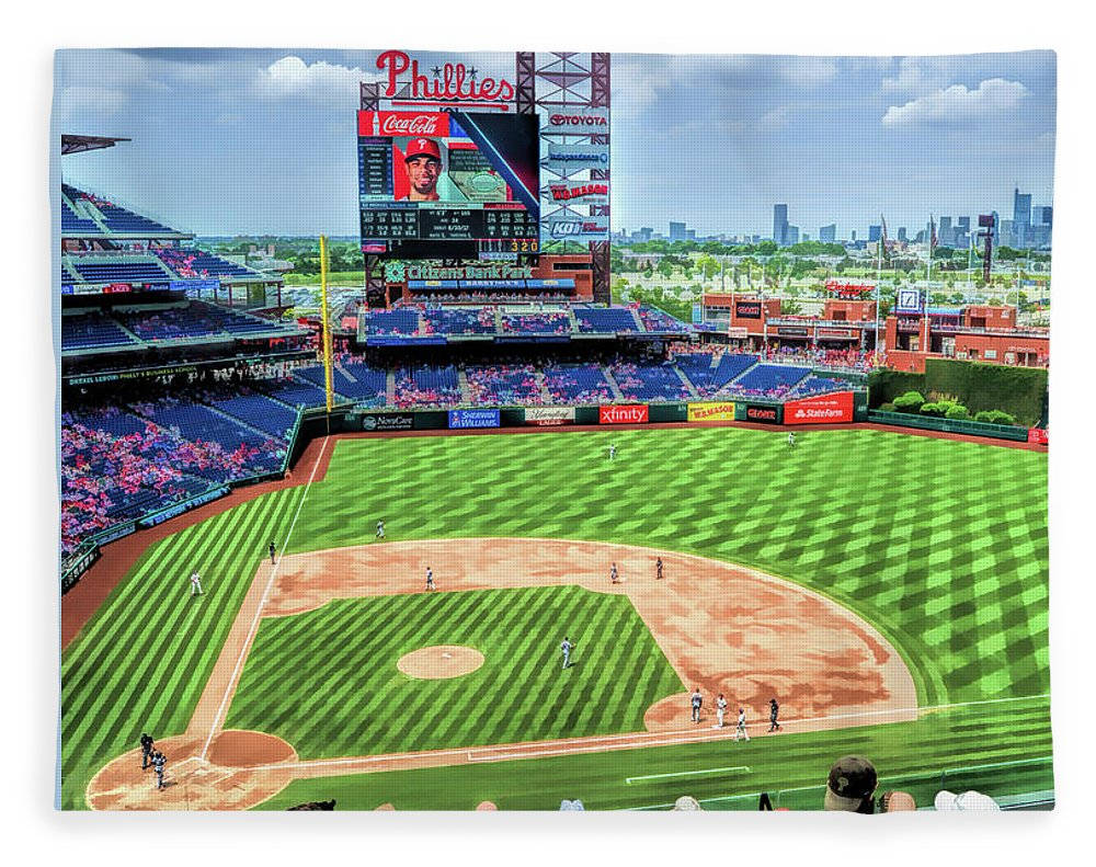 Phillies 桌布 壁紙 — 一個充滿活力的棒球場，擁有精心條紋的綠色場地，以及在部分多雲的天空下顯示費城人隊品牌的大型記分牌。