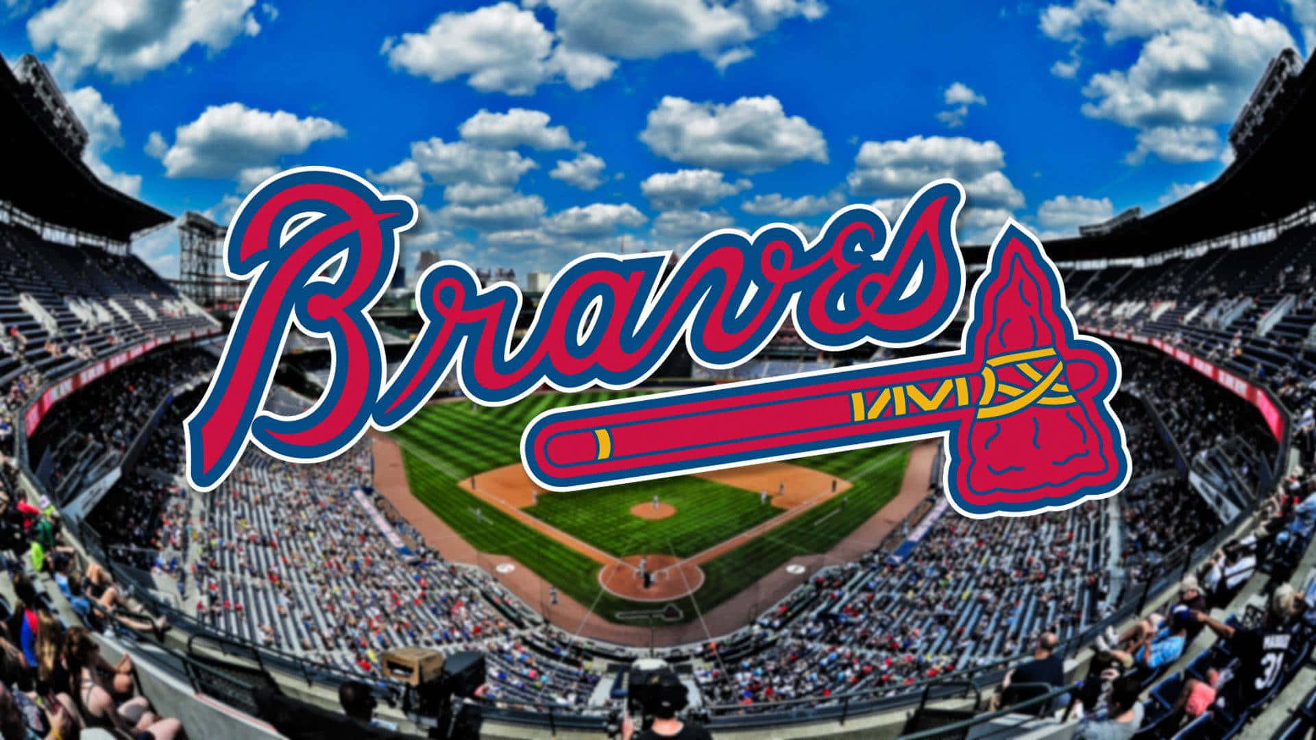 Atlanta Braves Desktop 桌布 壁紙 — 一個充滿活力的棒球場，擠滿了球迷，頭頂是明亮的藍天和蓬鬆的白雲。