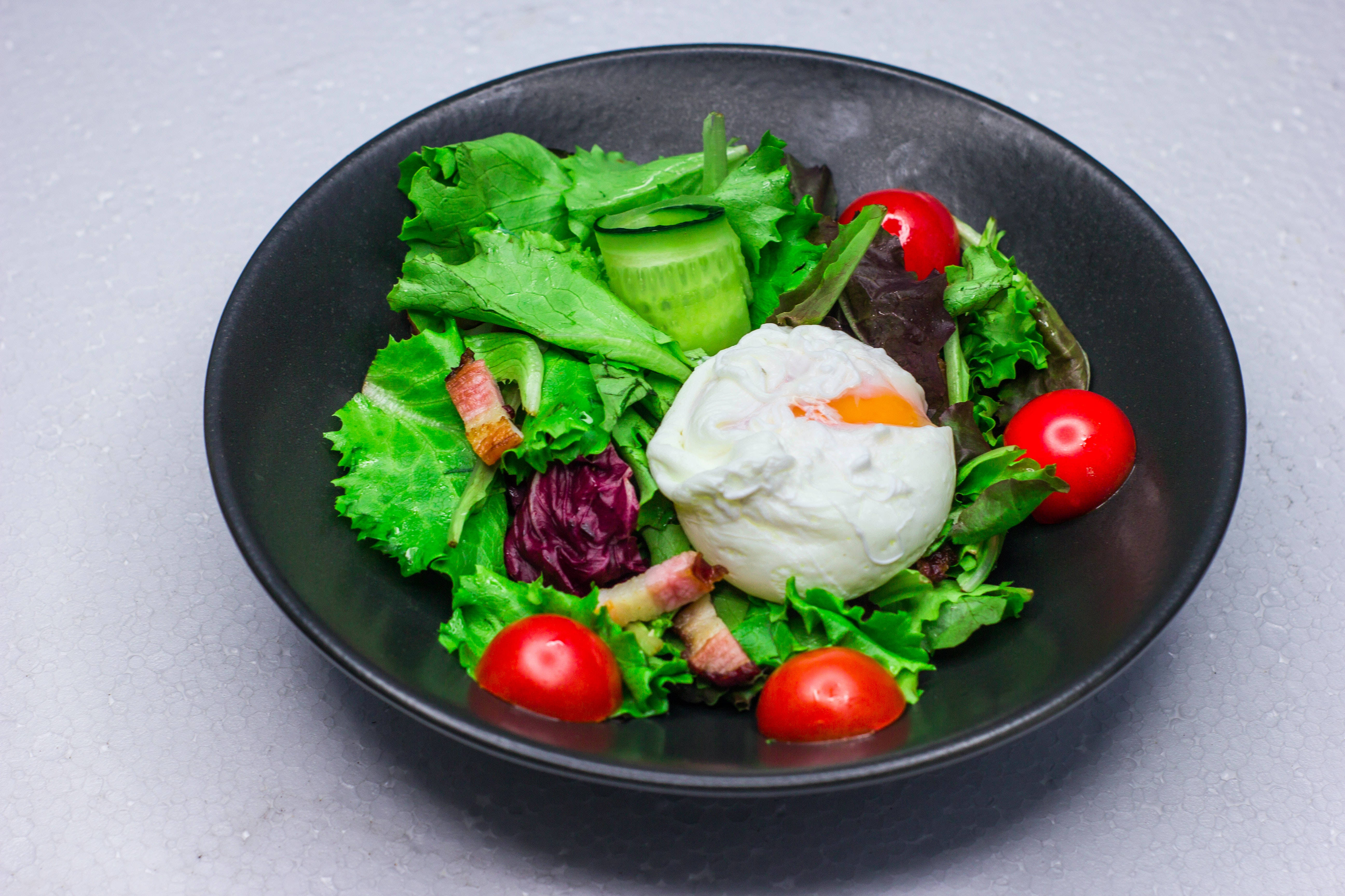 Salad 桌布 壁紙 — 一個充滿活力的沙拉，配有水煮蛋、櫻桃番茄和小黃瓜，放在一個霧面黑色的碗裡，置於灰色表面上。