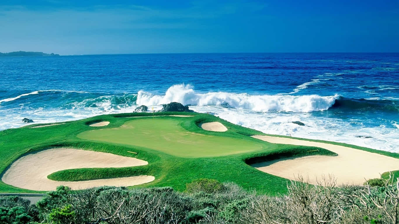 1366x768 Golf Course 桌布 壁紙 — 一個充滿活力的海岸高爾夫球場，擁有鬱鬱蔥蔥的綠色球道和沙坑，在清澈的藍天下被洶湧的海浪環繞。