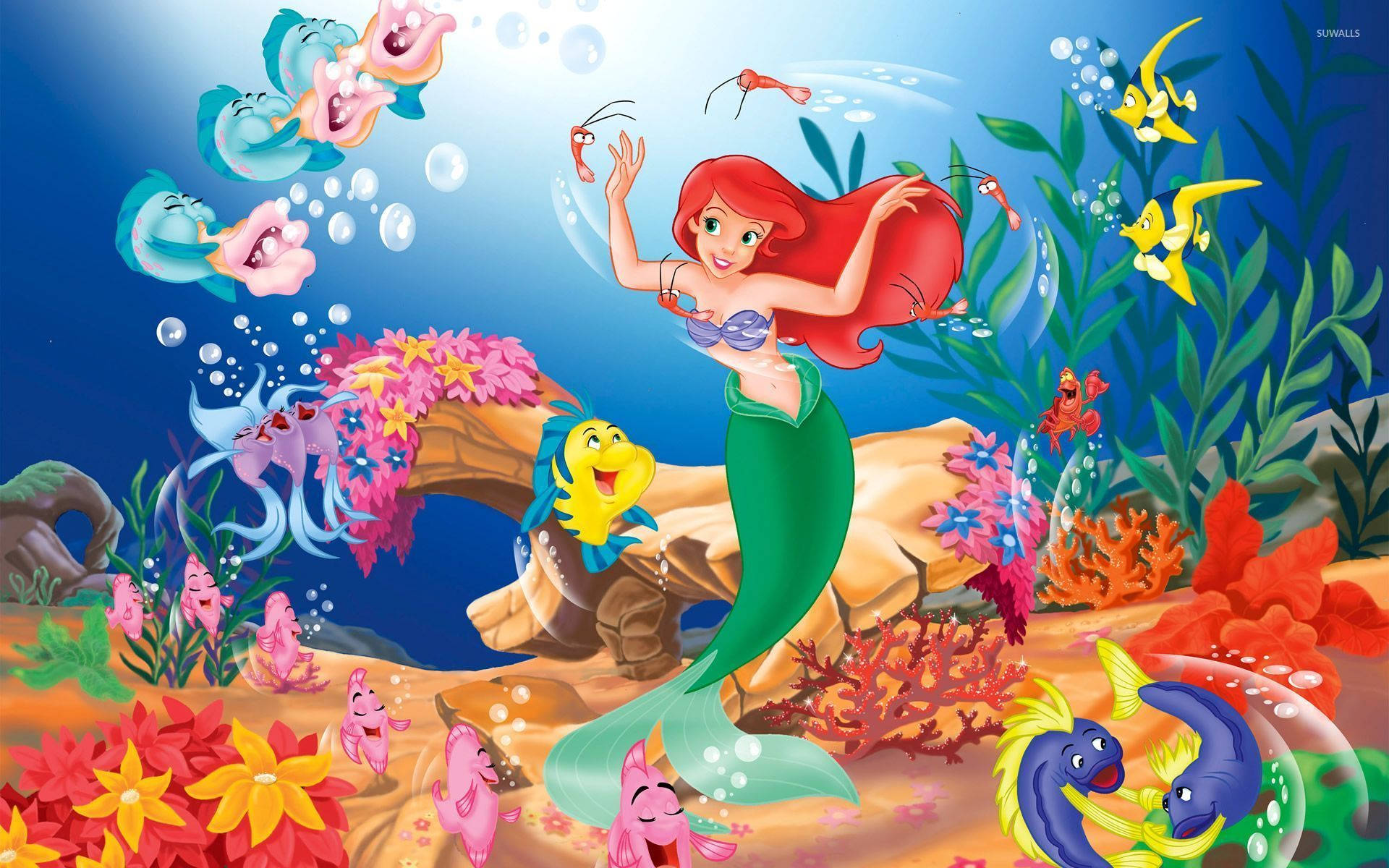 美人魚 桌布 壁紙 — 一個充滿活力的海底場景，美人魚艾莉爾和她的朋友們在色彩繽紛的珊瑚和頑皮的魚群中。