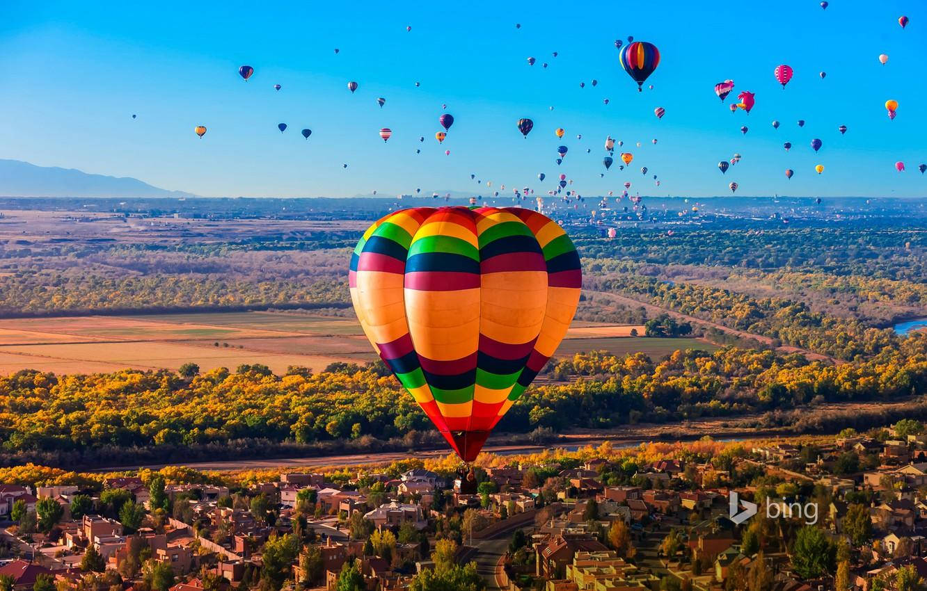 Balloon 桌布 壁紙 — 一個充滿活力的熱氣球節，色彩繽紛的氣球在陽光明媚的秋日山谷和小鎮上空翱翔，佈滿天空。