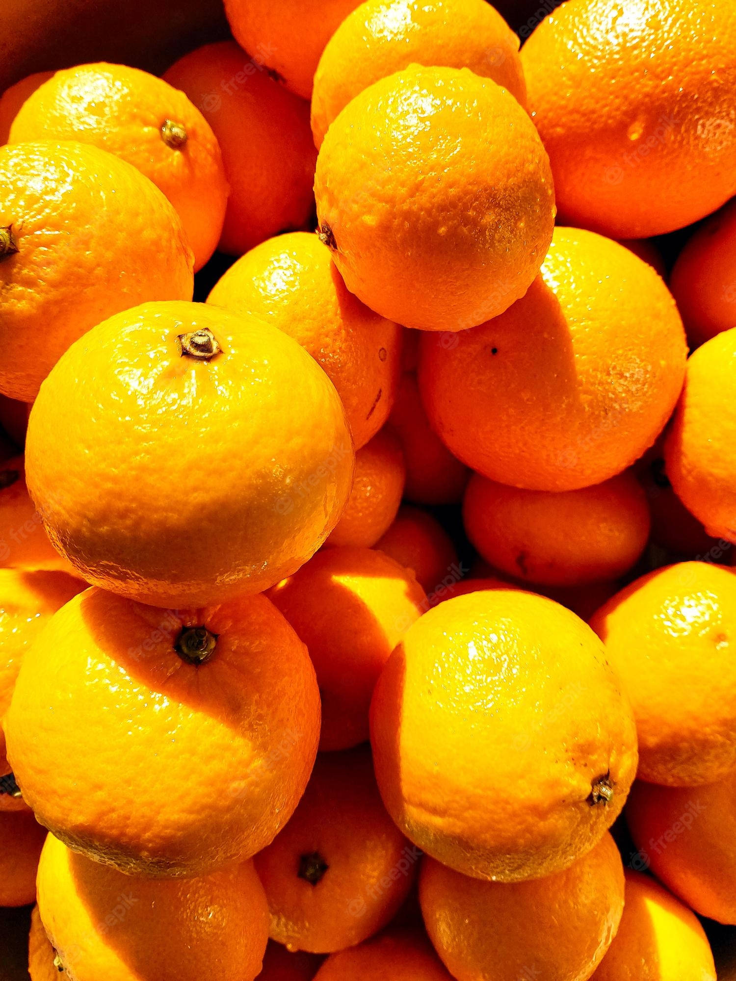 Fruit 桌布 壁紙 — 一個充滿活力的特寫，光澤成熟的橙子在溫暖的陽光下堆疊在一起，突顯其紋理果皮。
