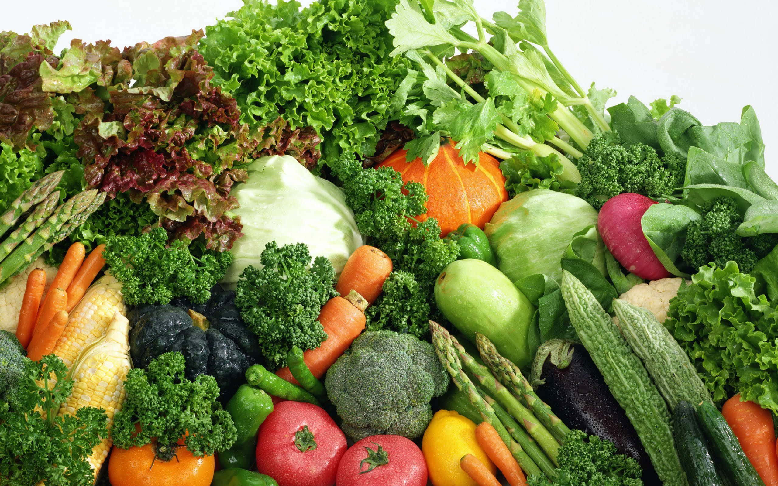 Vegetables 桌布 壁紙 — 一個充滿活力的特寫，展示了各種新鮮蔬菜，如胡蘿蔔、西蘭花和生菜，堆成色彩繽紛的一堆。