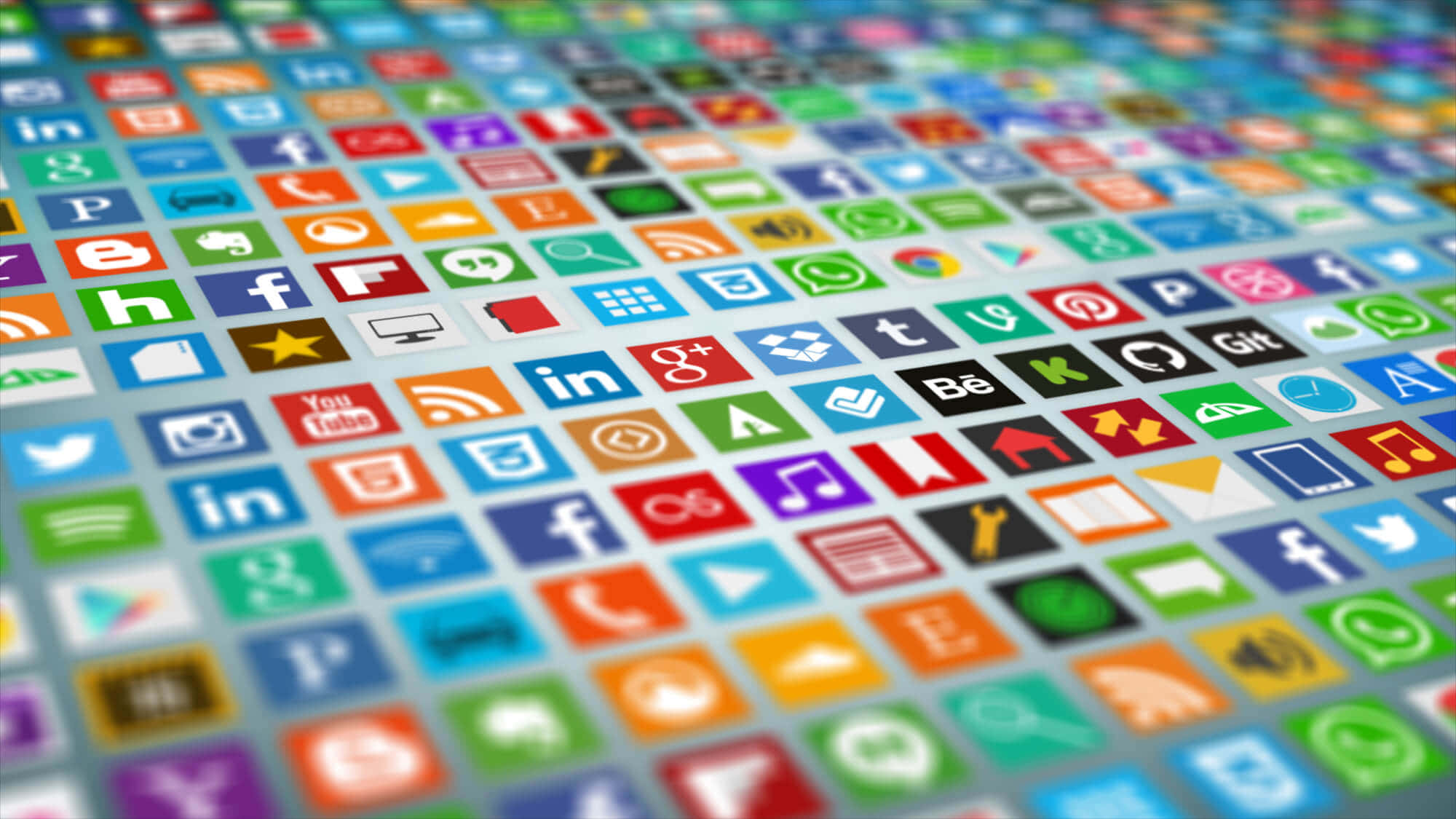 Social Media Logos 桌布 壁紙 — 一個充滿活力的特寫，色彩繽紛的應用程式圖示排列在數位螢幕上的網格中，景深較淺。