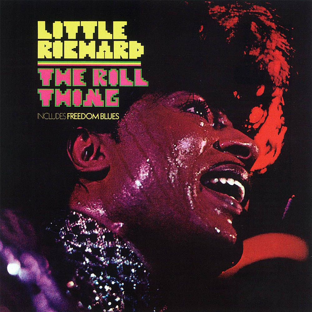recording 桌布 壁紙 — 一個充滿活力的特寫鏡頭，Little Richard 在戲劇性的紅色和紫色舞台燈光下，穿著閃閃發光的服裝熱情地唱歌。