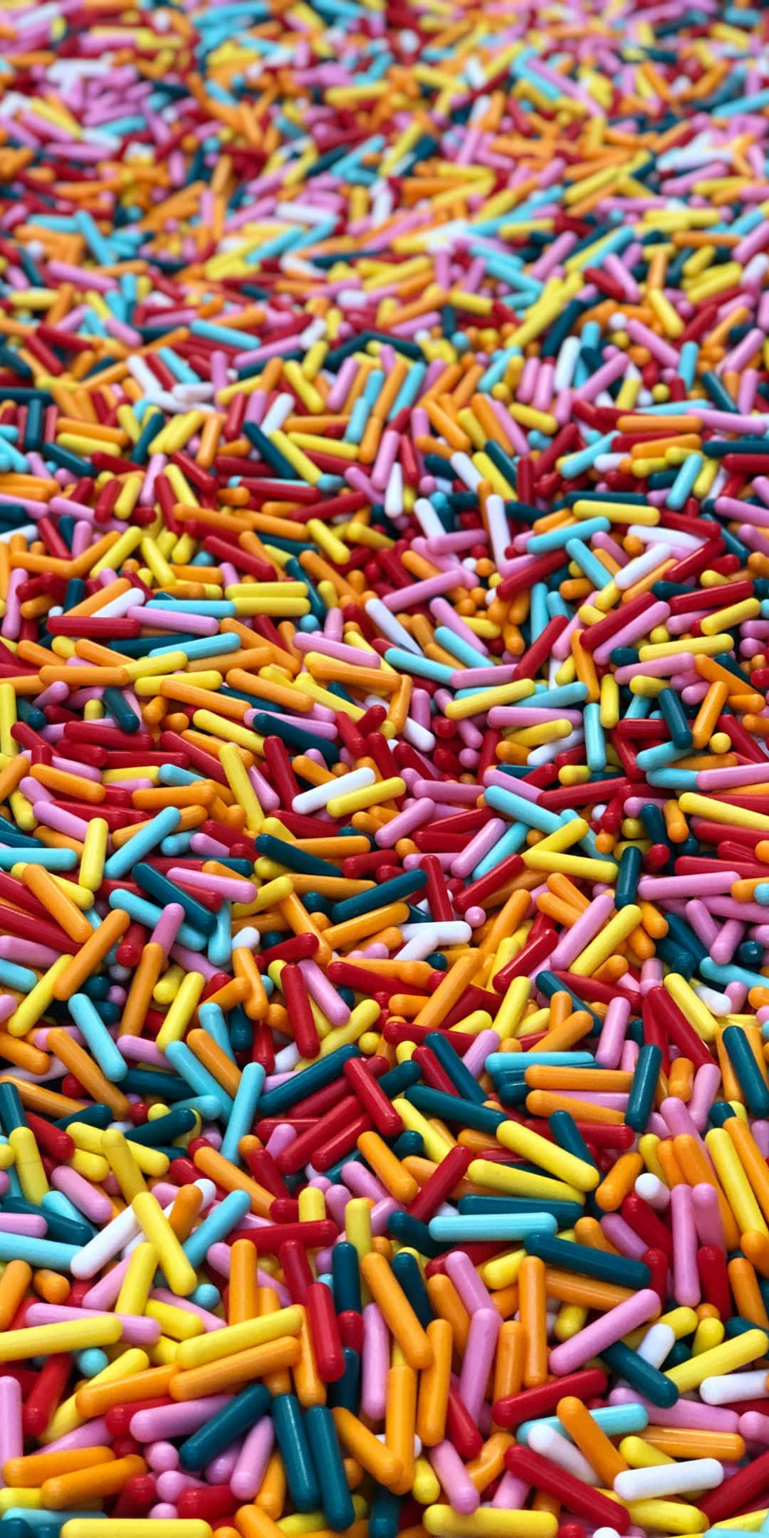 Sprinkles 桌布 壁紙 — 一個充滿活力的特寫鏡頭，展示了密集散落在畫面中的多色圓柱形糖粒。