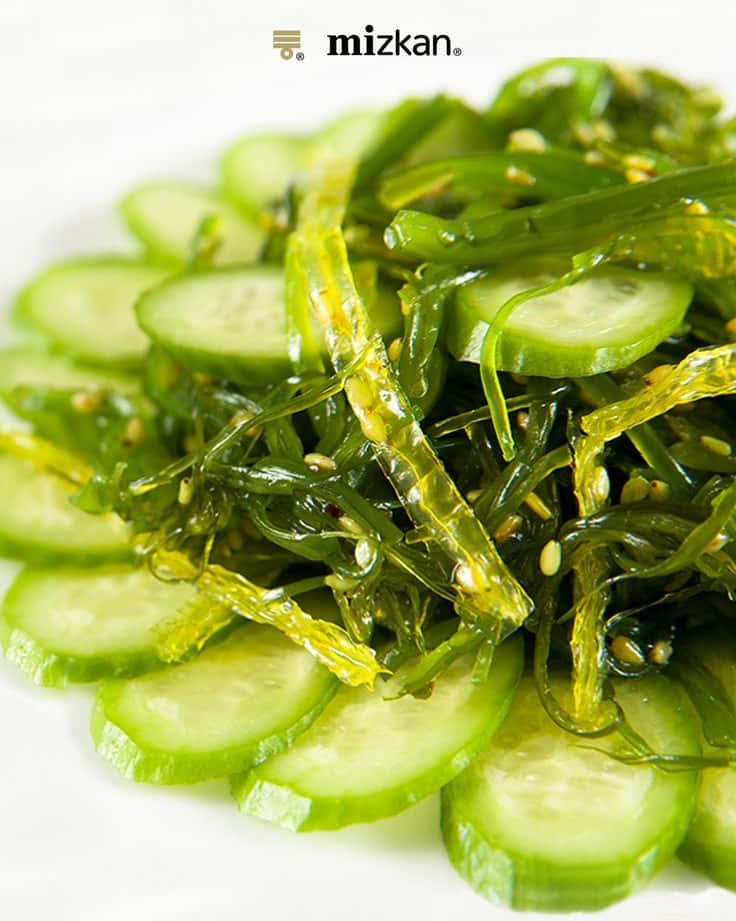 Seaweed 桌布 壁紙 — 一個充滿活力的特寫鏡頭，展示放在白色盤子上的日本海藻黃瓜沙拉，並撒上芝麻作裝飾。