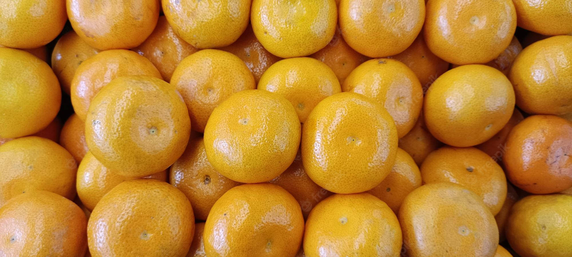 Fruit 桌布 壁紙 — 一個充滿活力的特寫鏡頭，展示緊密堆疊的亮橙色柑橘，突顯其紋理果皮和多汁的吸引力。