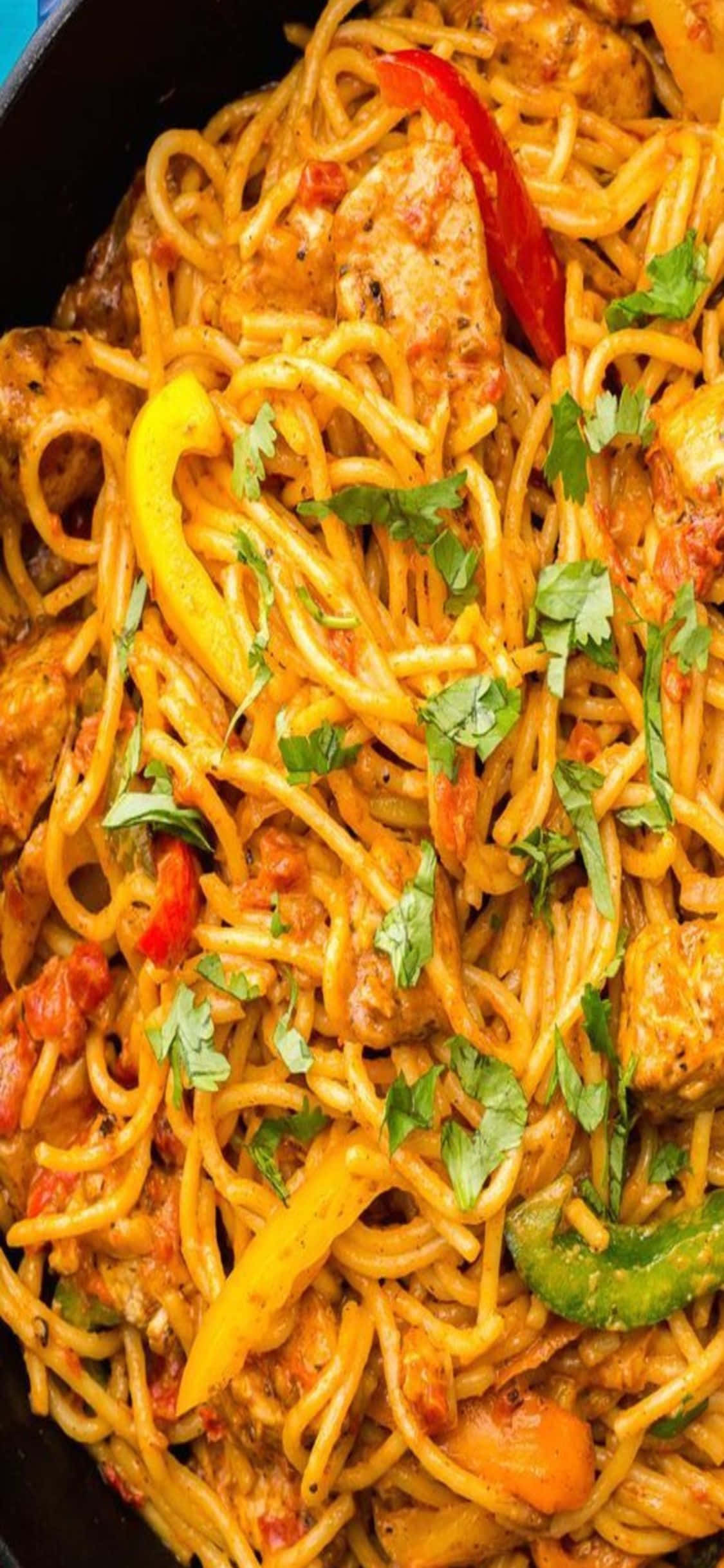 iPhone X Pasta 桌布 壁紙 — 一個充滿活力的特寫鏡頭，展示辣味義大利麵配雞肉和色彩繽紛的甜椒，並以新鮮香菜點綴。