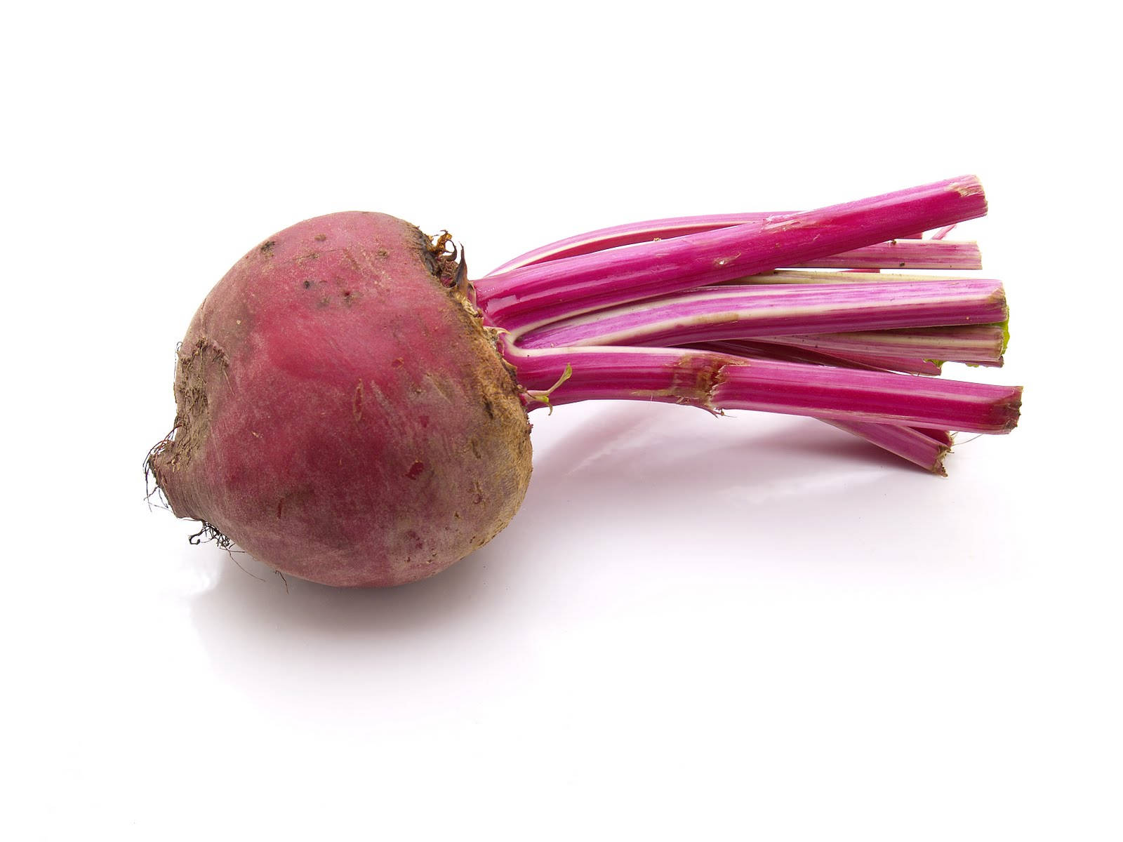 beetroot 桌布 壁紙 — 一個充滿活力的粉紅色甜菜根，帶有新鮮的莖，放在乾淨的白色表面上，展示其樸實的質地和豐富的色彩。