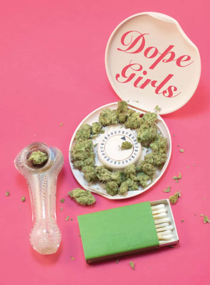 Cute Stoner 桌布 壁紙 — 一個充滿活力的粉紅色背景上有一個白色圓形容器，標有「Dope Girls」，裡面裝滿了綠色大麻花蕾、一個玻璃水煙槍和一個綠色火柴盒。