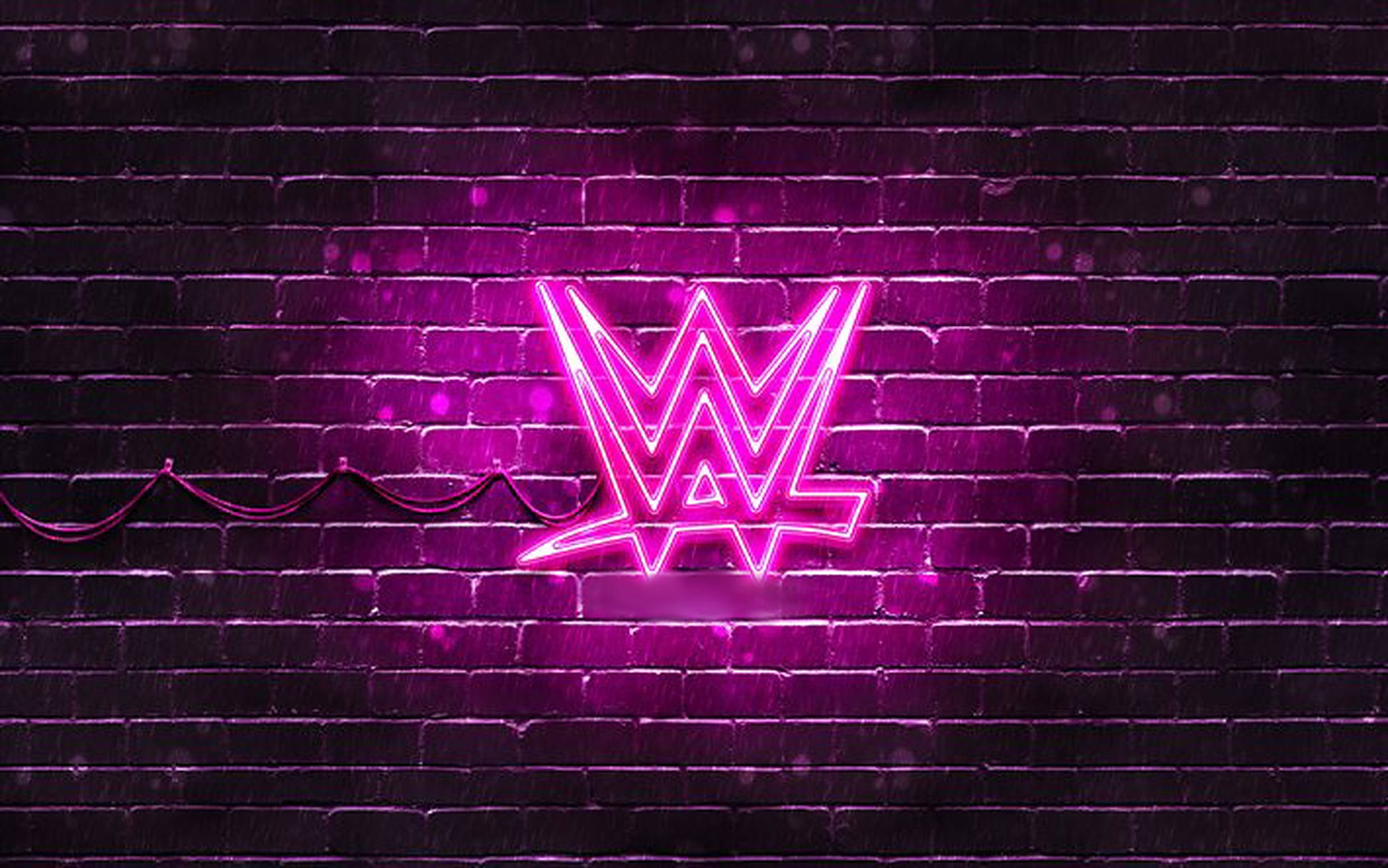 WWE 桌布 壁紙 — 一個充滿活力的粉紅色霓虹燈WWE標誌在黑暗的磚牆上發光，帶有可見的電線和環境光粒子。