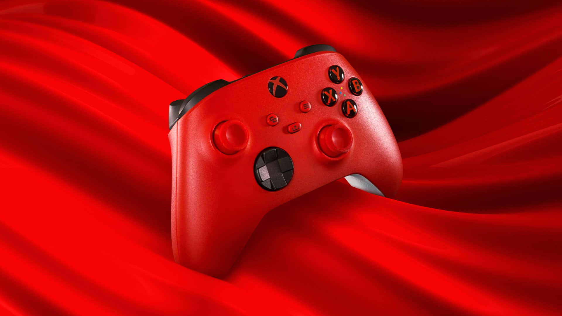 Xbox 桌布 壁紙 — 一個充滿活力的紅色Xbox控制器優雅地放置在流動的深紅色布料背景上。