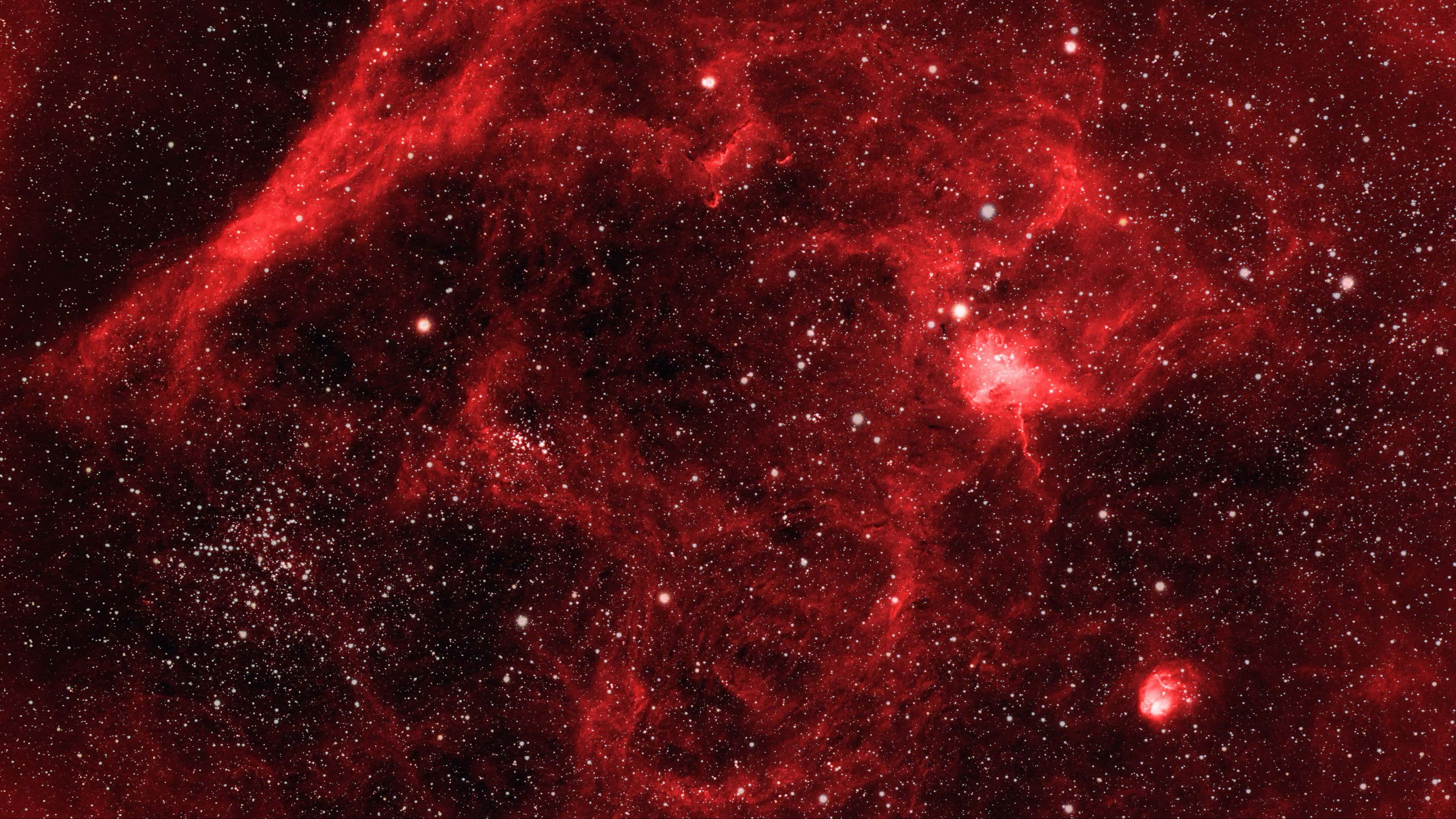 紅色動圖 桌布 壁紙 — 一個充滿活力的紅色星雲，在黑暗的宇宙背景下，發光的氣體和散落的星星旋轉著。