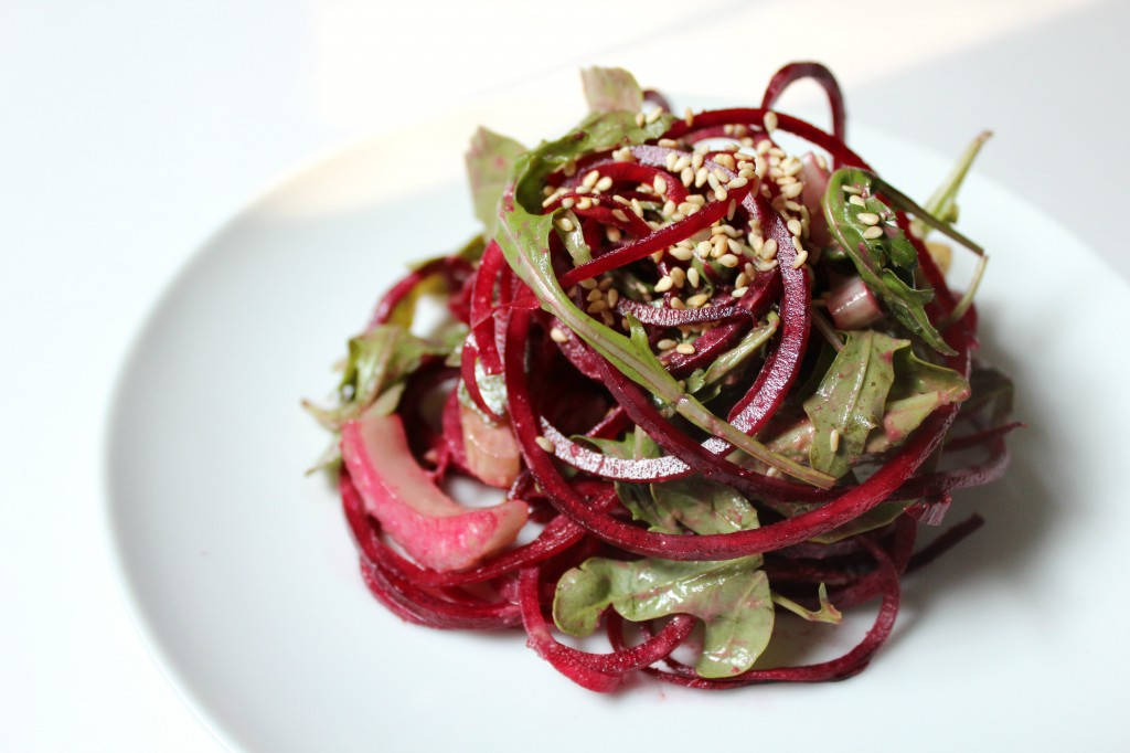 beetroot 桌布 壁紙 — 一個充滿活力的紅菜頭沙拉，配上芝麻和青菜，藝術地堆疊在白色盤子上。