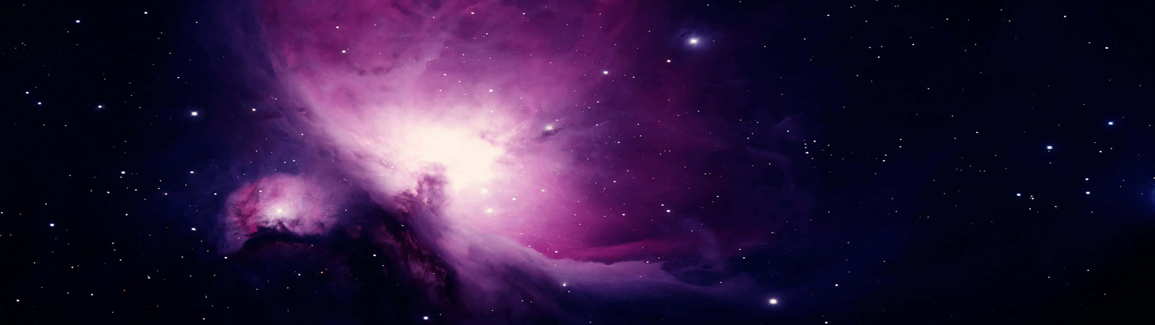太空 桌布 壁紙 — 一個充滿活力的紫色和粉紅色星雲在深空星場中發光，伴隨著明亮的宇宙雲和散落的星星。