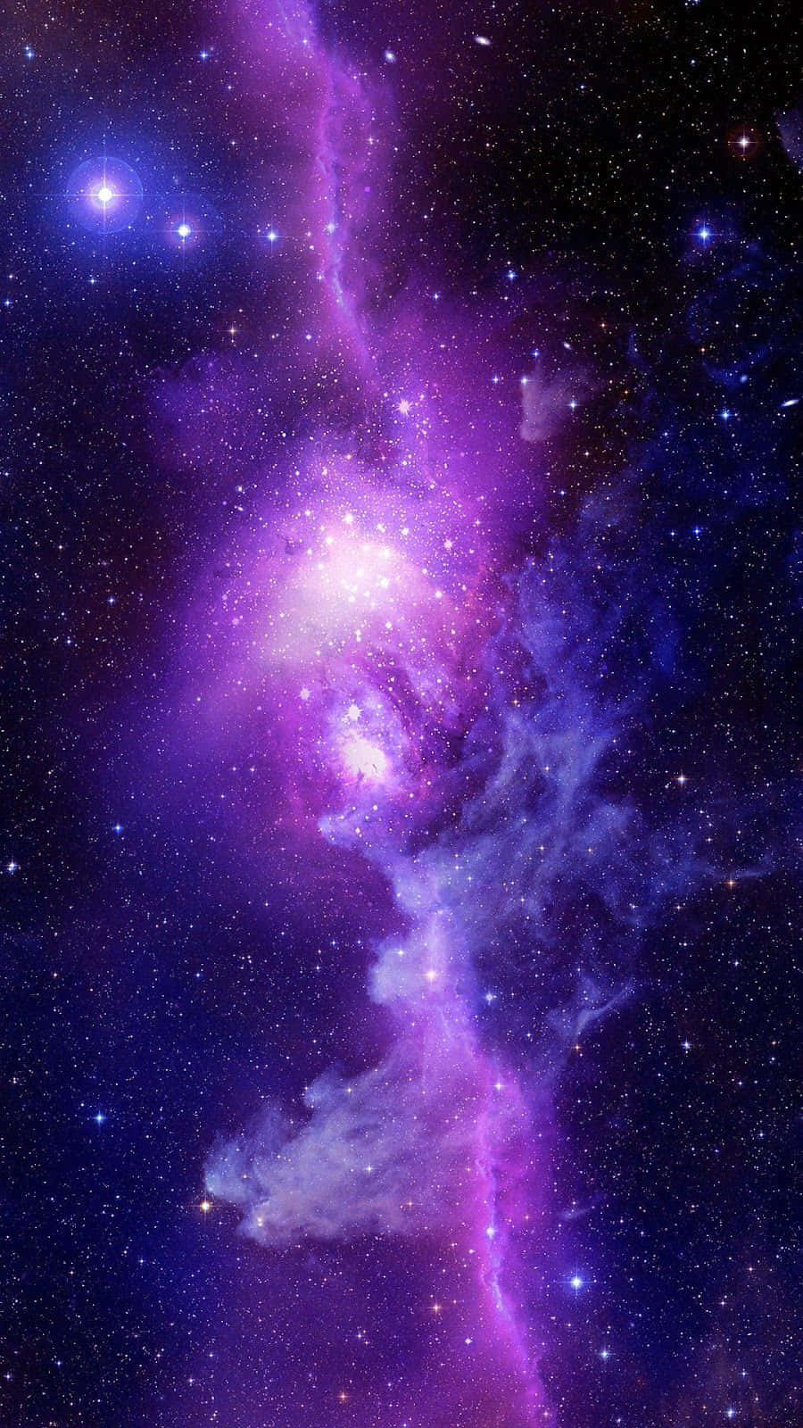 太空 桌布 壁紙 — 一個充滿活力的紫色和藍色星雲，在深邃的宇宙虛空中旋轉，閃爍著發光的星星。