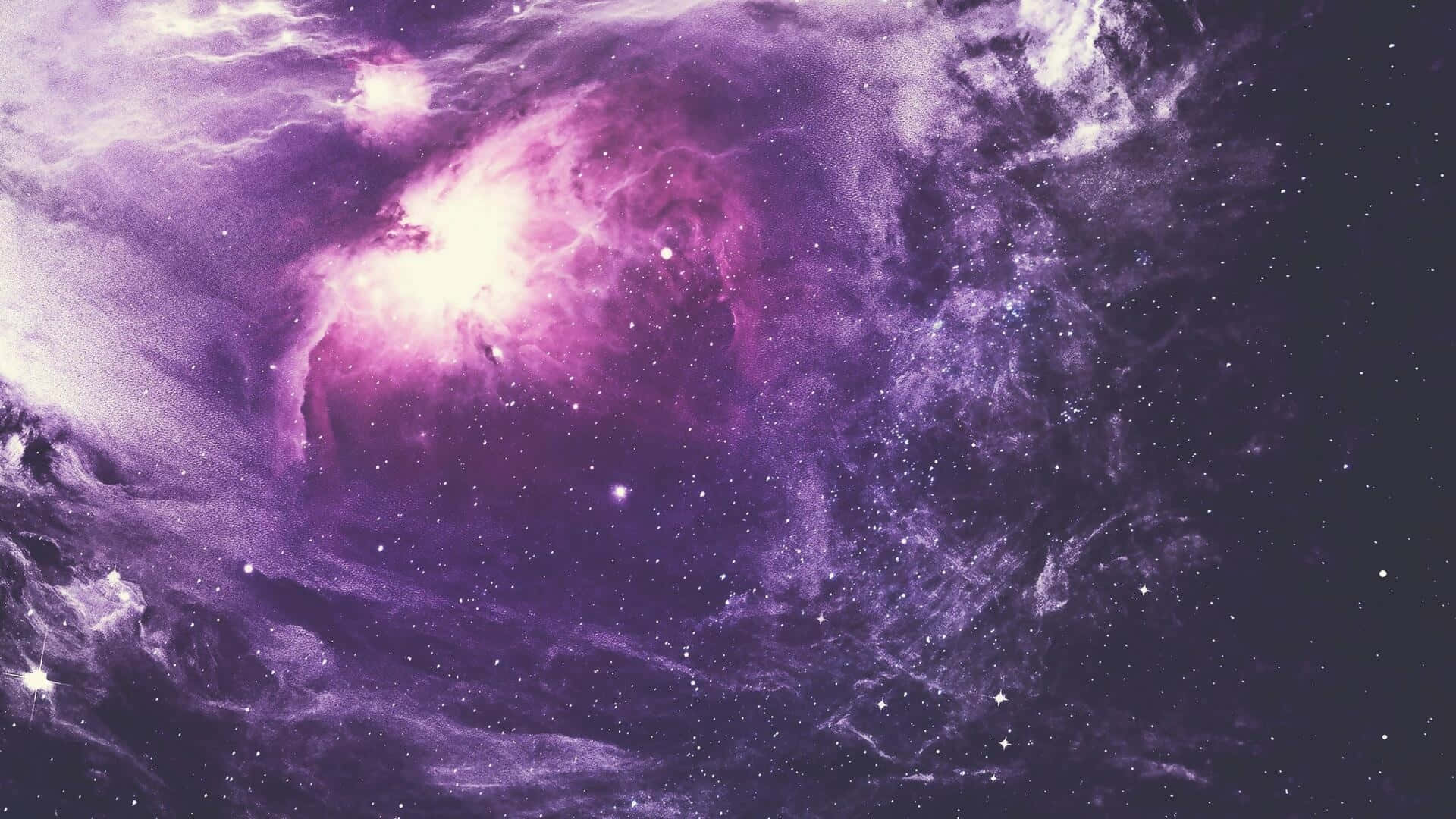 Space Desktop 桌布 壁紙 — 一個充滿活力的紫色星雲，發光的雲層和散落的星星照亮了深邃太空的廣闊。