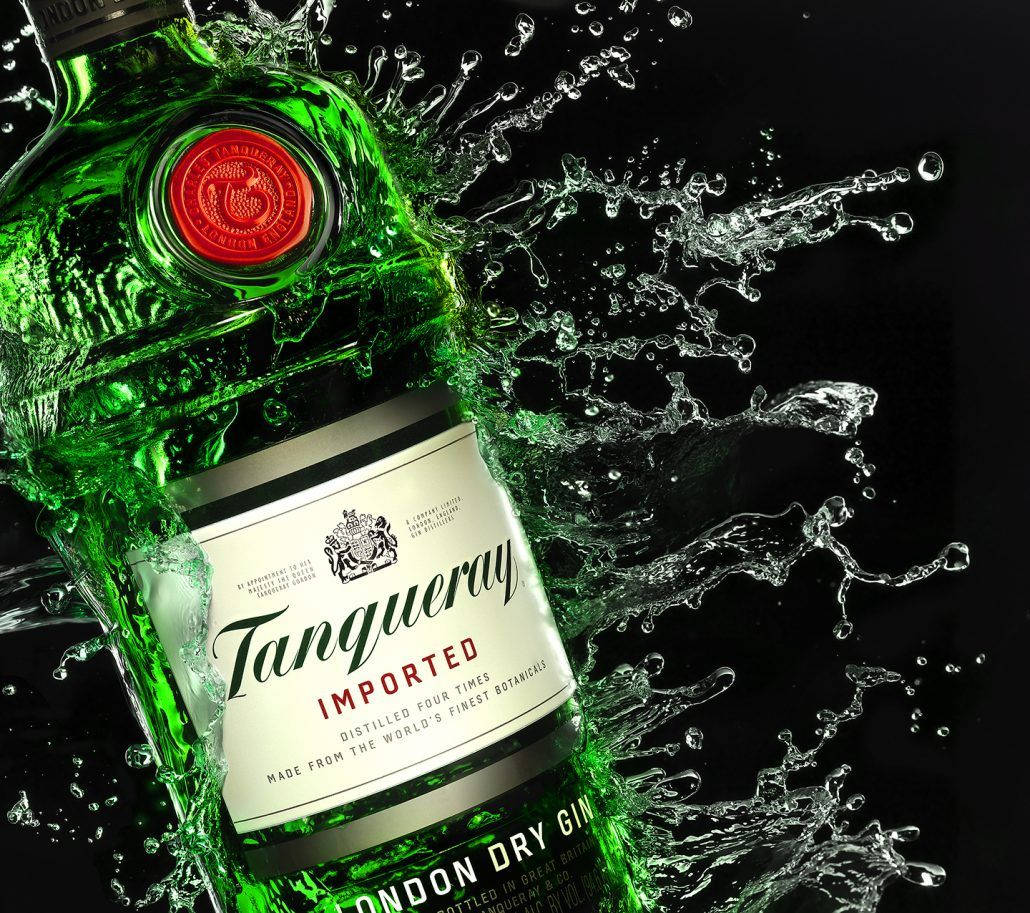 Drink 桌布 壁紙 — 一個充滿活力的綠色Tanqueray琴酒瓶在純黑背景下爆發出動態的水花。