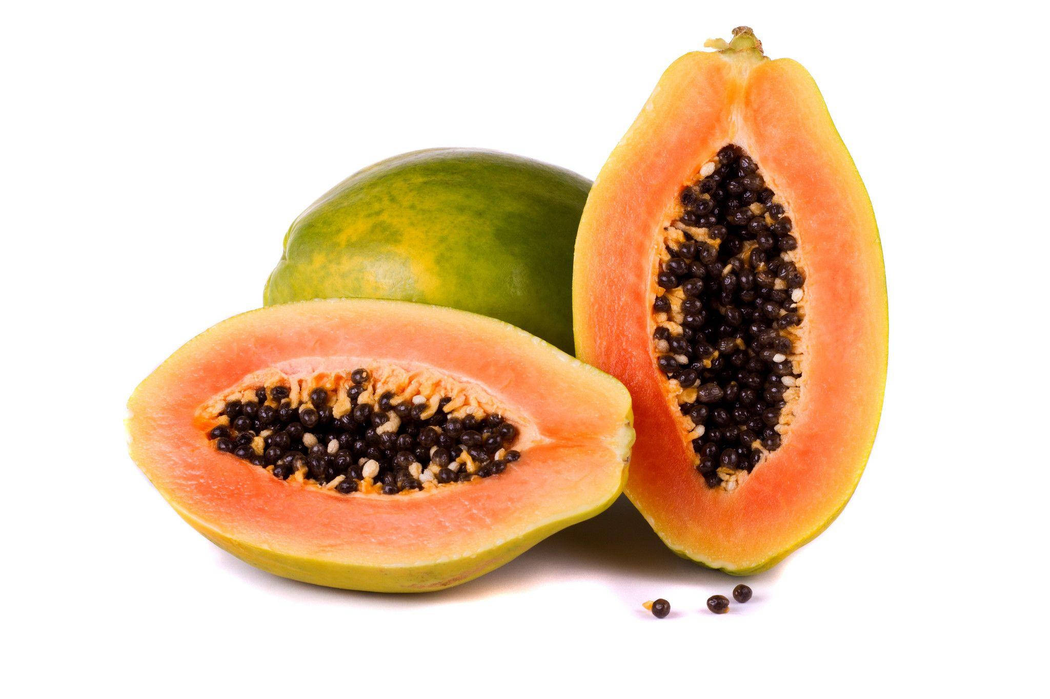 Fruit 桌布 壁紙 — 一個充滿活力的綠色和橙色木瓜切開，露出多汁的果肉和黑色的種子，背景是潔淨的白色。