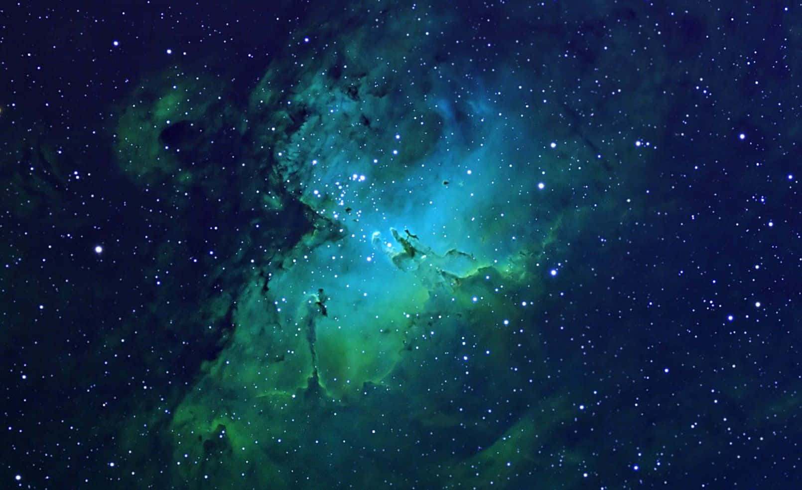 Green Galaxy 桌布 壁紙 — 一個充滿活力的綠色和藍色星雲，在深邃的宇宙夜空中閃爍著星光。