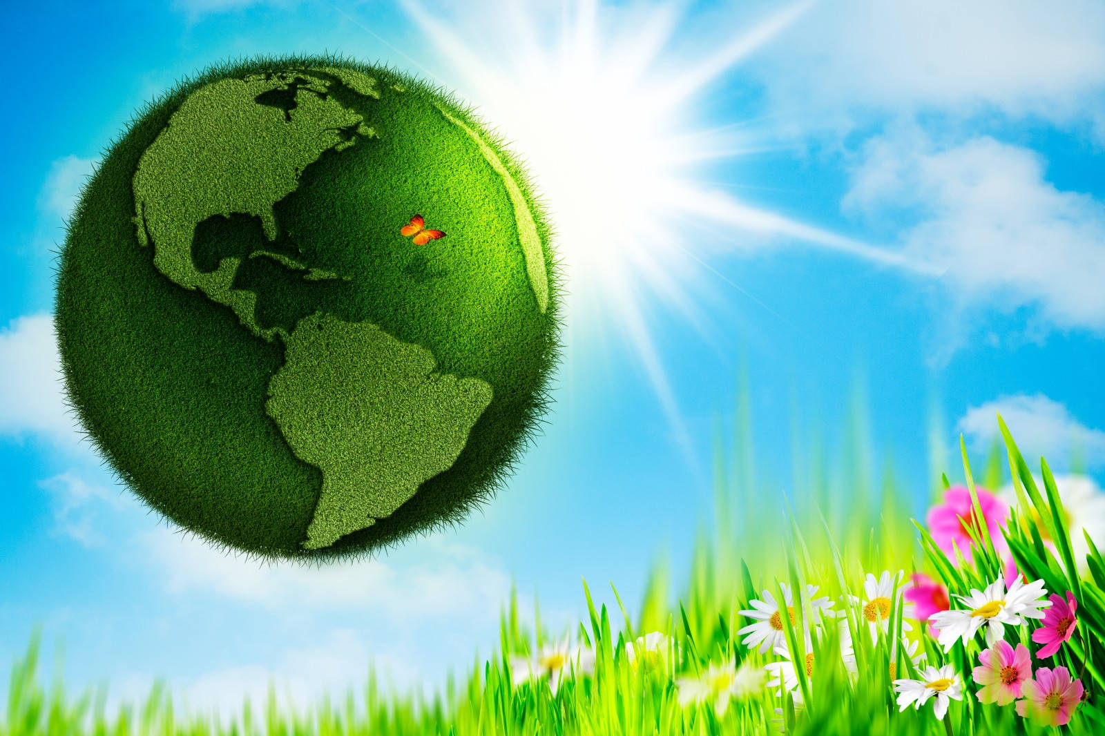 Earth Day 桌布 壁紙 — 一個充滿活力的綠色草地覆蓋的地球儀在明亮的太陽下漂浮，伴隨著色彩繽紛的花朵和一隻蝴蝶，在清澈的藍天中。