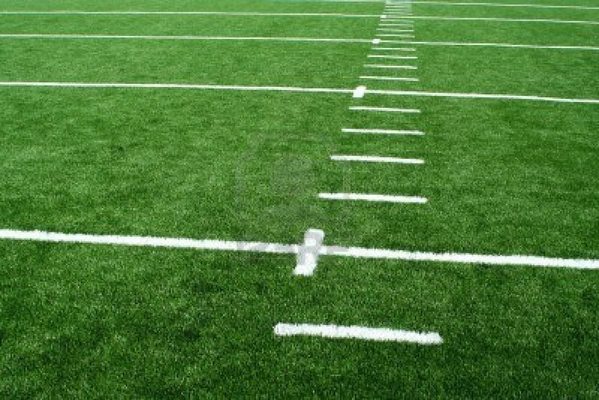 Football Field 桌布 壁紙 — 一個充滿活力的綠色足球場的特寫視圖，清晰的白色碼線延伸到遠方。