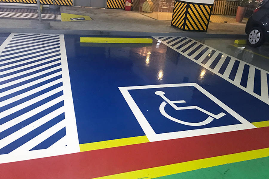 彩色動圖 桌布 壁紙 — 一個充滿活力的藍色無障礙停車位，標有白色輪椅標誌，並以大膽的條紋和色彩繽紛的塗漆邊緣圍繞。