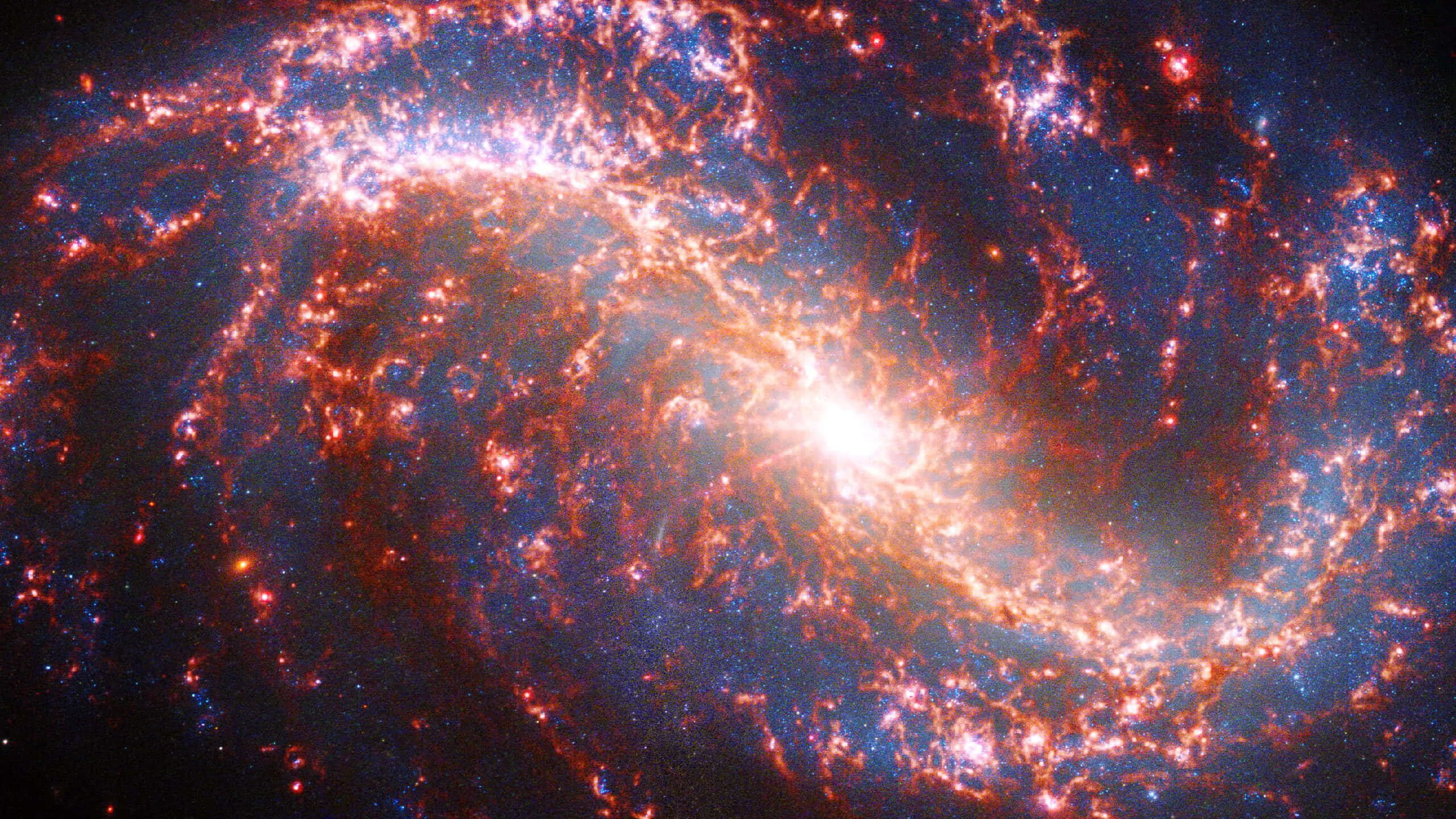 astronomy 桌布 壁紙 — 一個充滿活力的螺旋星系，在深邃的黑色虛空中旋轉著火橙色和電藍色的宇宙塵埃。