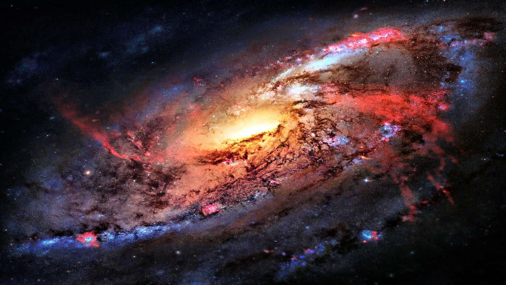 Colorful Space 桌布 壁紙 — 一個充滿活力的螺旋星系，在繁星點點的宇宙虛空中旋轉，呈現出火紅、金色和冷藍色。