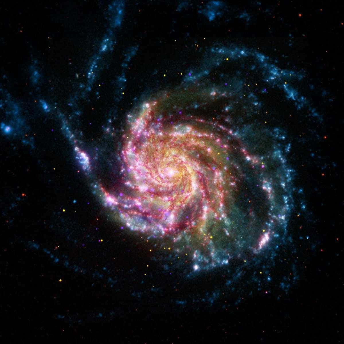 Beautiful Galaxy 桌布 壁紙 — 一個充滿活力的螺旋星系，在繁星點點的宇宙背景下，旋轉著粉紅色、橙色和藍色的色調。