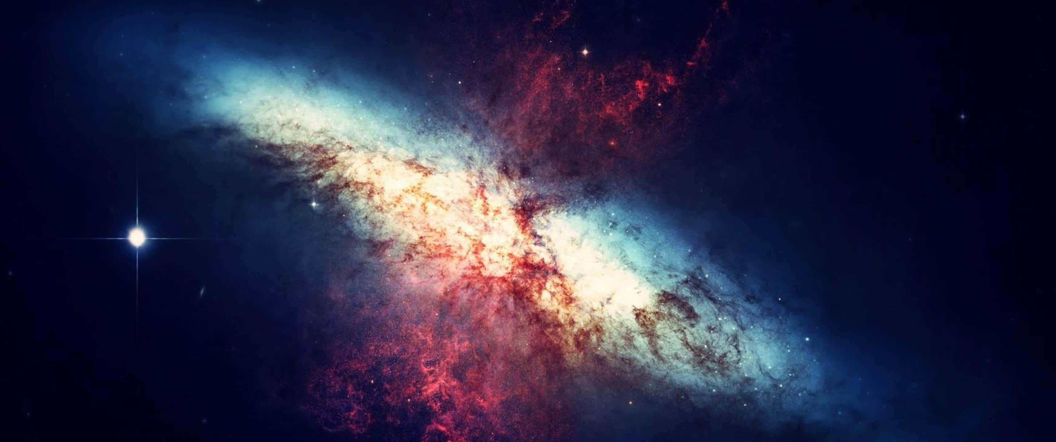 桌布 壁紙 — 一個充滿活力的螺旋星系，在繁星點點的宇宙背景下旋轉著紅色和藍色的星雲。