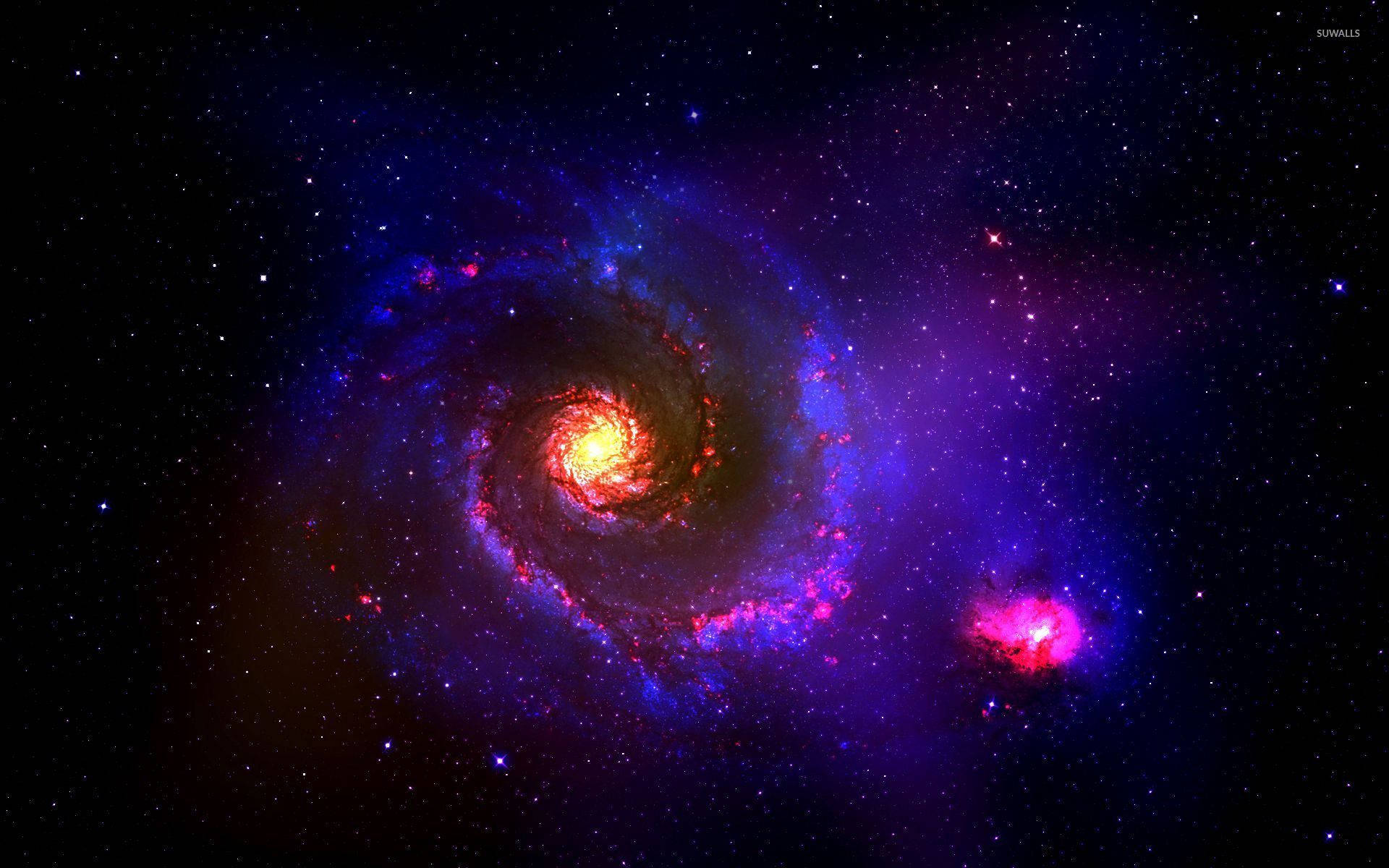 Colorful Galaxy 桌布 壁紙 — 一個充滿活力的螺旋星系，帶有熾熱的核心和旋轉的藍紫色旋臂，在星空中閃耀，附近還有一個粉紅色星雲。