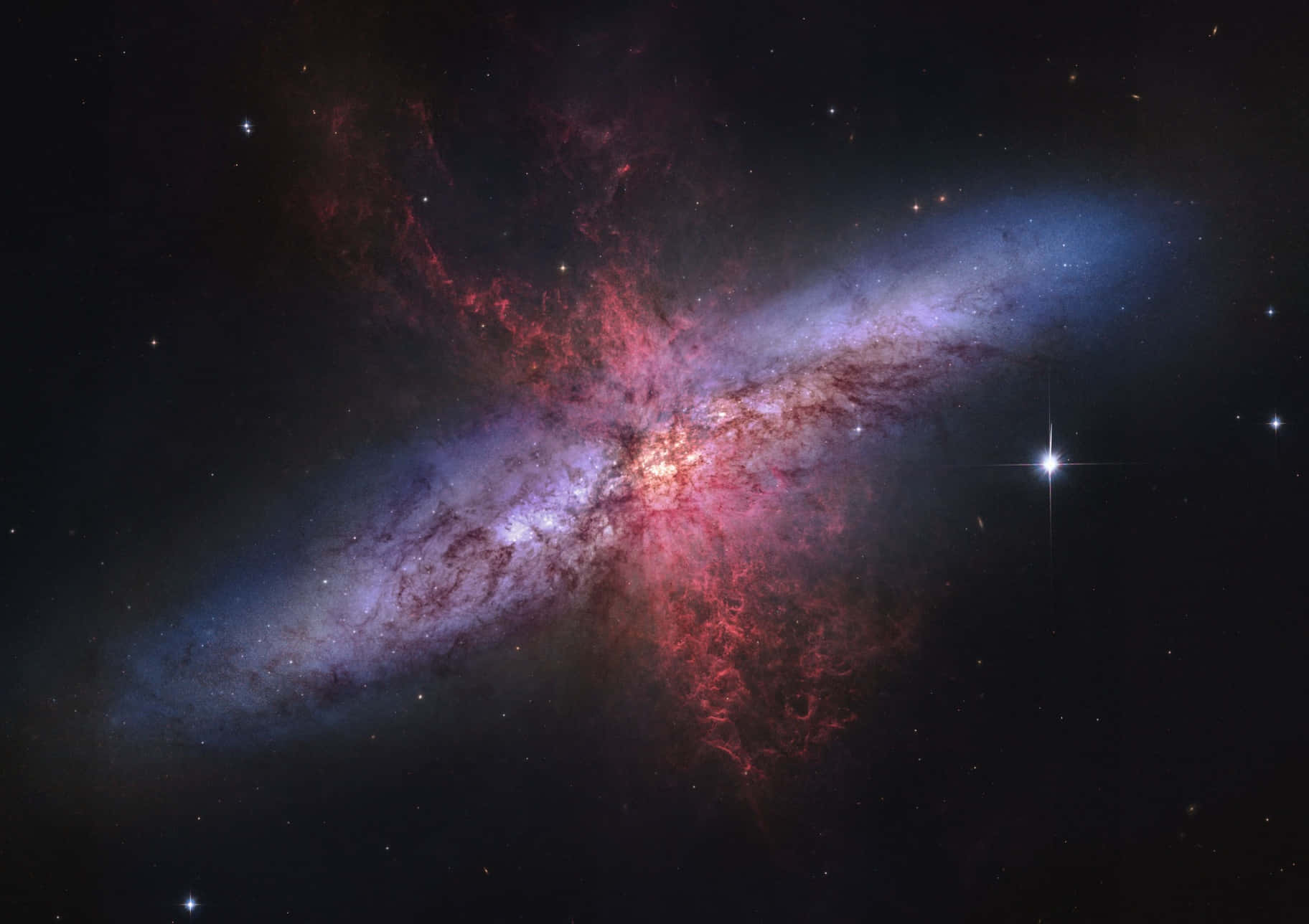 Nasa Galaxy 桌布 壁紙 — 一個充滿活力的螺旋星系，有旋轉的紅色和藍色星雲，以及明亮的星星，背景是黑暗的宇宙。