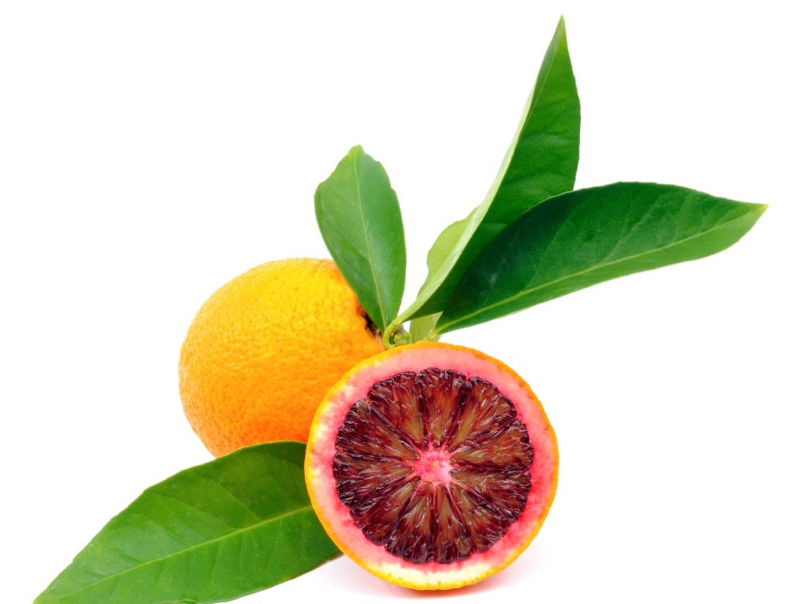 Fruit 桌布 壁紙 — 一個充滿活力的血橙切半，露出深紅色的果肉，旁邊放著一個完整的柳橙和新鮮的綠葉，在白色背景上。