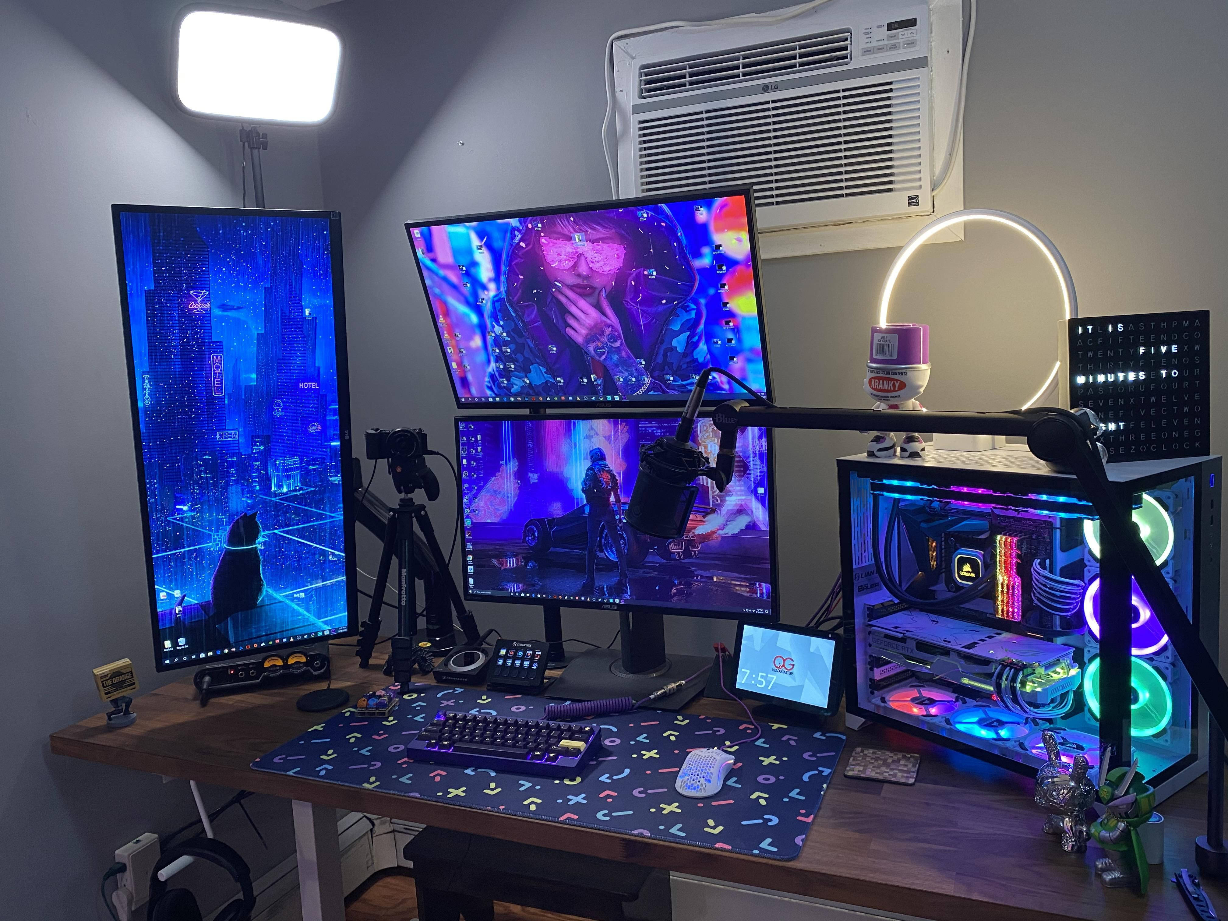Gaming Setup 桌布 壁紙 — 一個充滿活力的遊戲設置，配有三個顯示器顯示霓虹賽博朋克場景，發光的RGB電腦，以及在明亮工作室燈光下的彩色滑鼠墊。