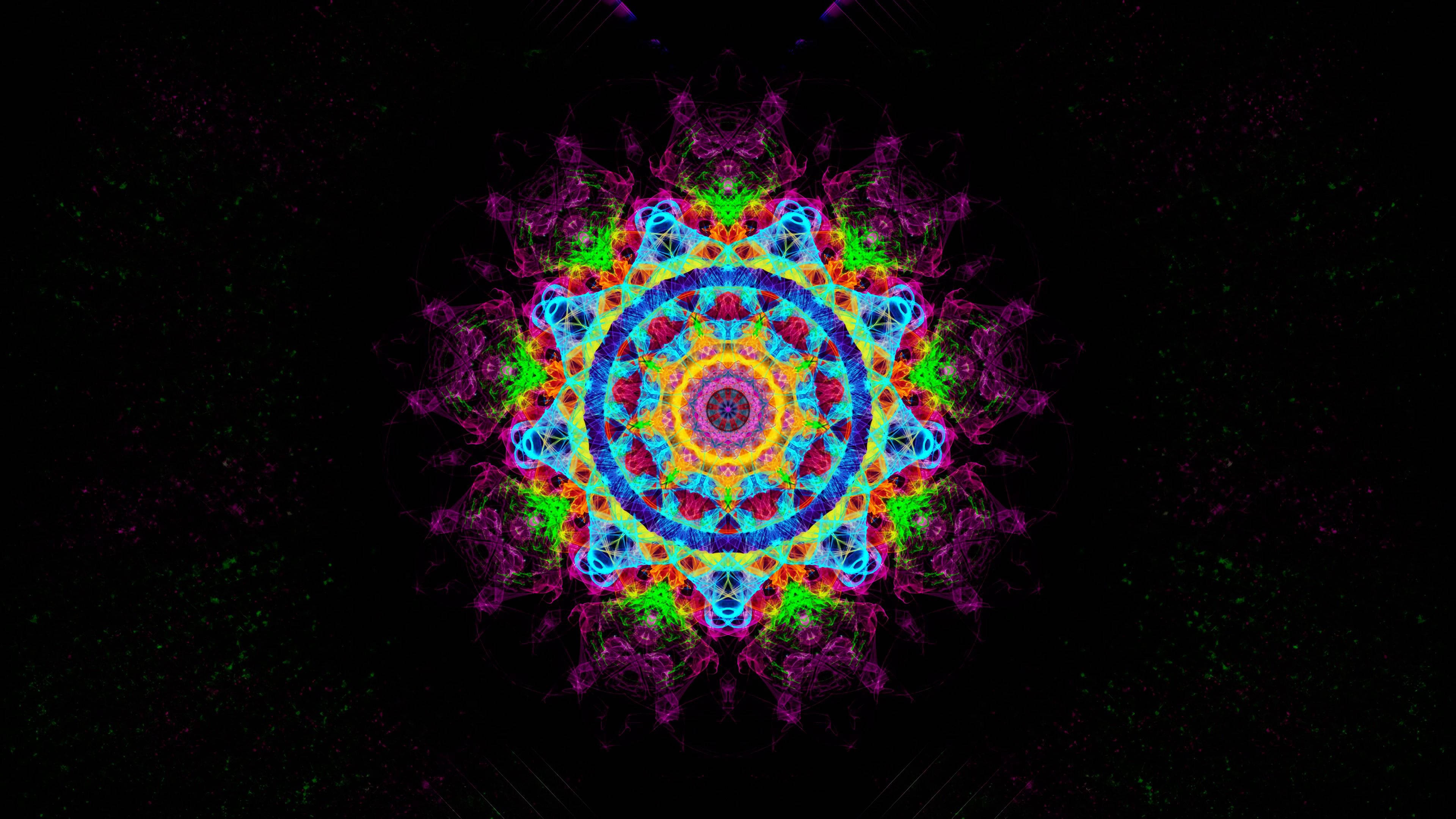 曼陀羅 桌布 壁紙 — 一個充滿活力的霓虹曼陀羅，帶有發光的藍色、綠色和紫色碎形圖案，在星光點點的黑色背景上散發光芒。