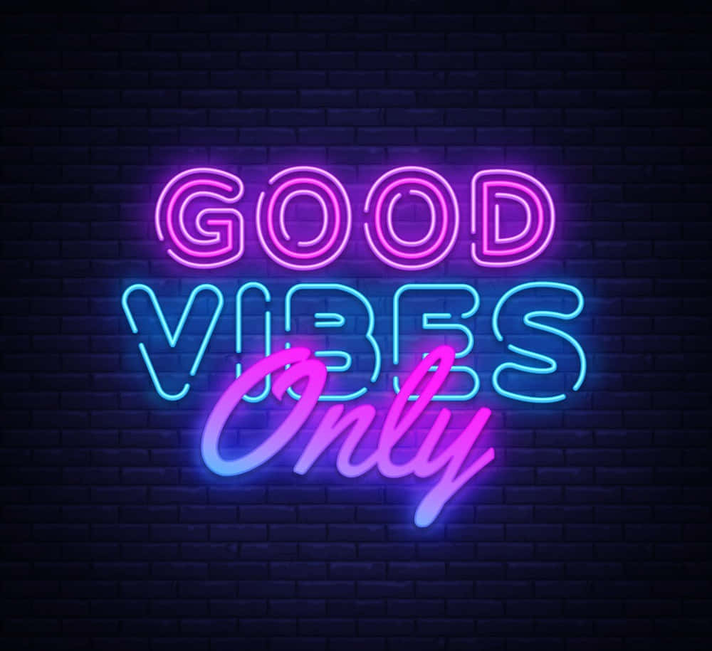 美學 桌布 壁紙 — 一個充滿活力的霓虹燈牌，上面寫著「GOOD VIBES Only」，在深色磚牆上發出粉紅色和藍色的光芒。