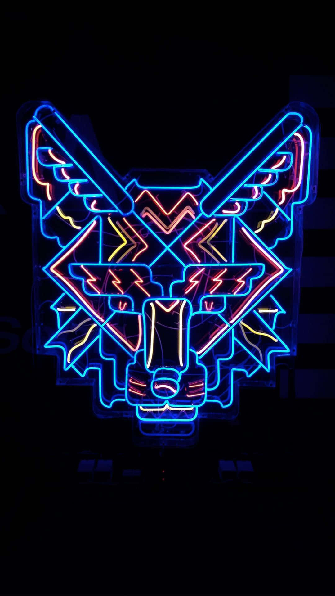 Neon Lights Aesthetic 桌布 壁紙 — 一個充滿活力的霓虹燈牌描繪了一個風格化的狼頭，帶有幾何圖案，在黑色背景上發出藍色、粉紅色和黃色的光芒。