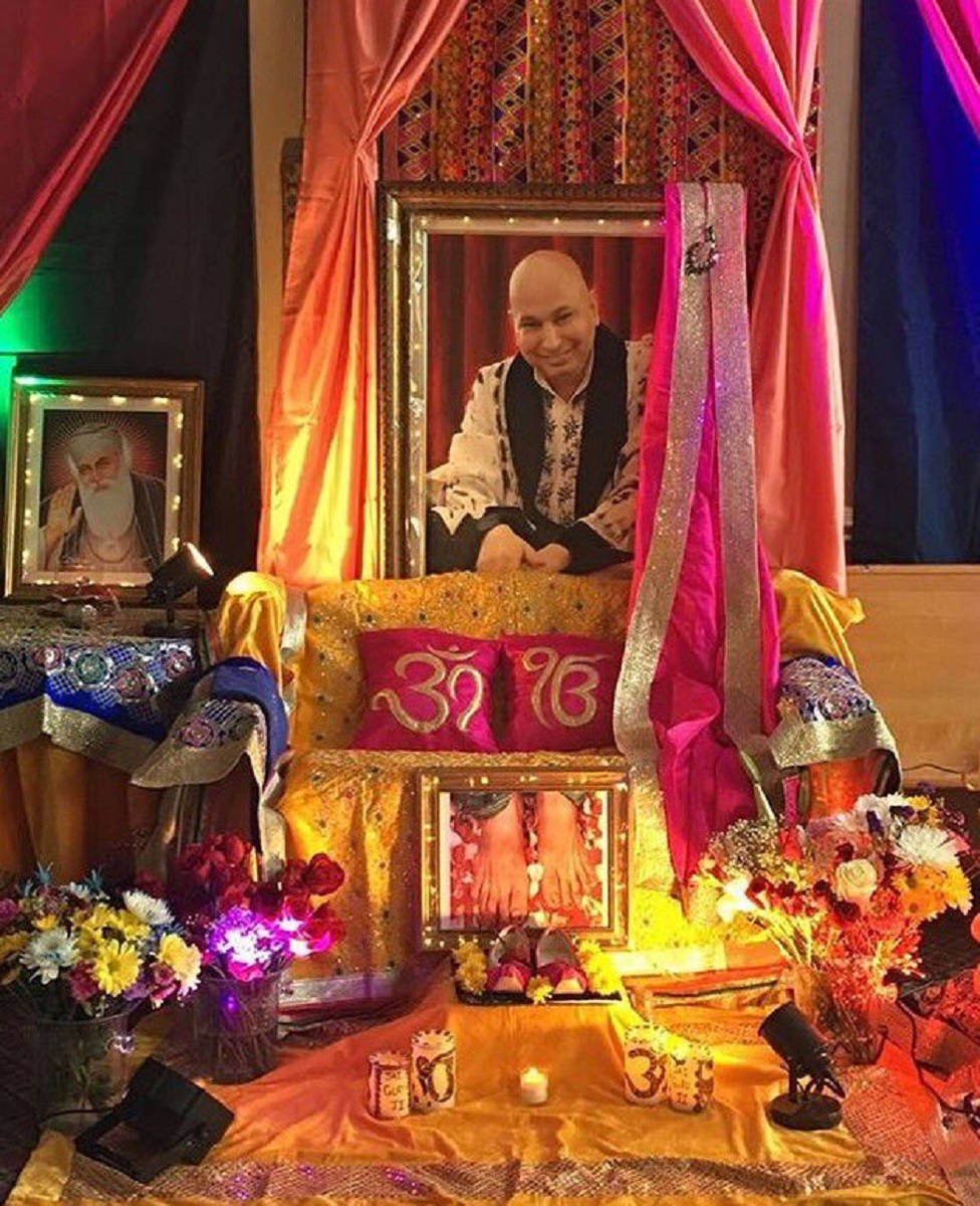 guru nanak dev ji 桌布 壁紙 — 一個充滿活力的靈性祭壇，裝飾著裱框肖像、發光的燈光、鮮花和神聖符號，在溫暖的環境照明下。