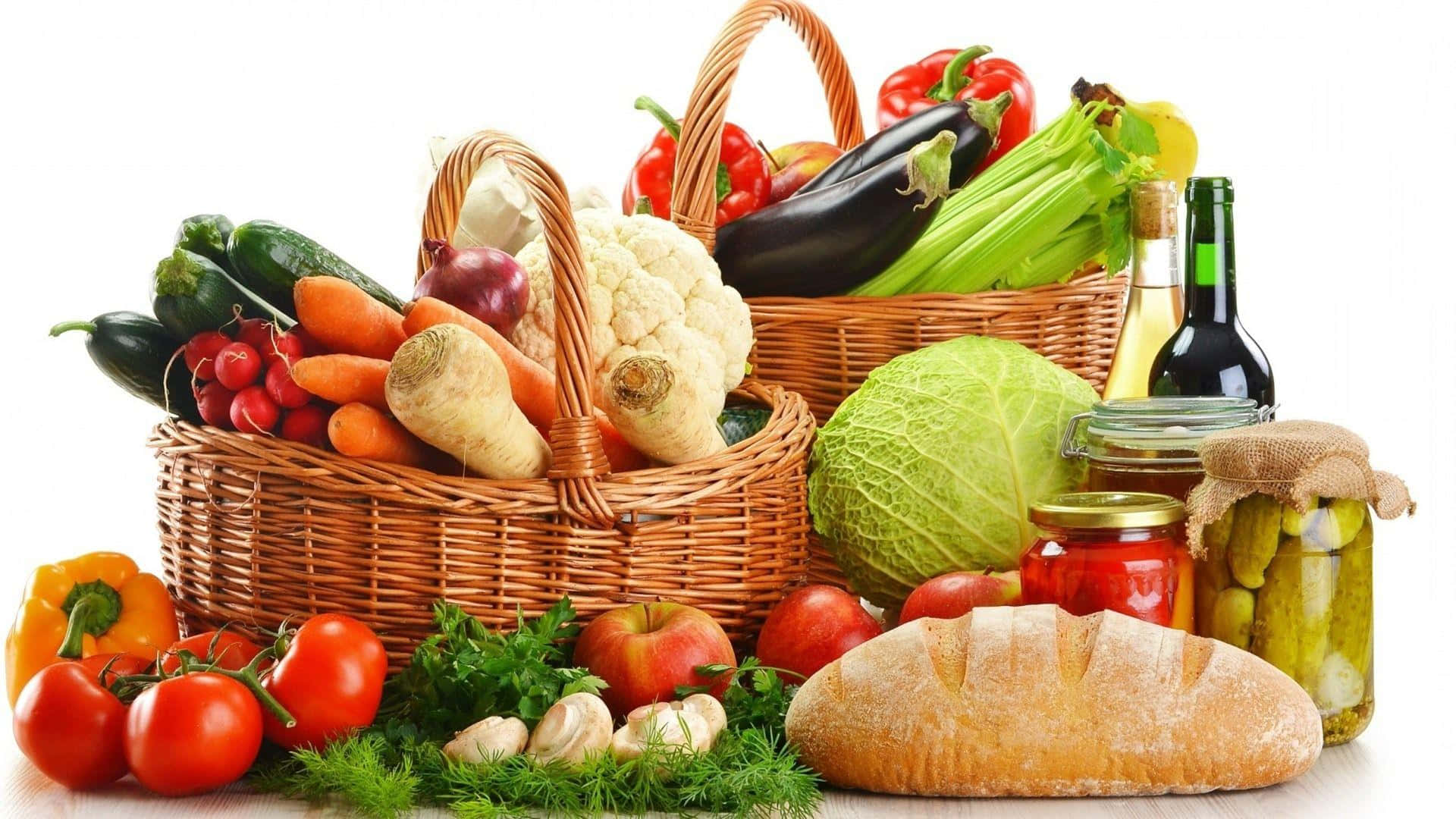 Healthy Food 桌布 壁紙 — 一個充滿活力的靜物畫，新鮮農產品、麵包和罐子整齊地擺放在柳條籃子裡，背景是乾淨的白色。