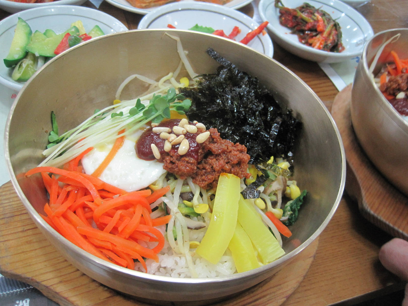 烹飪 桌布 壁紙 — 一個充滿活力的韓國石鍋拌飯碗，裝滿米飯、色彩繽紛的蔬菜和美味配料，放在金屬碗中。