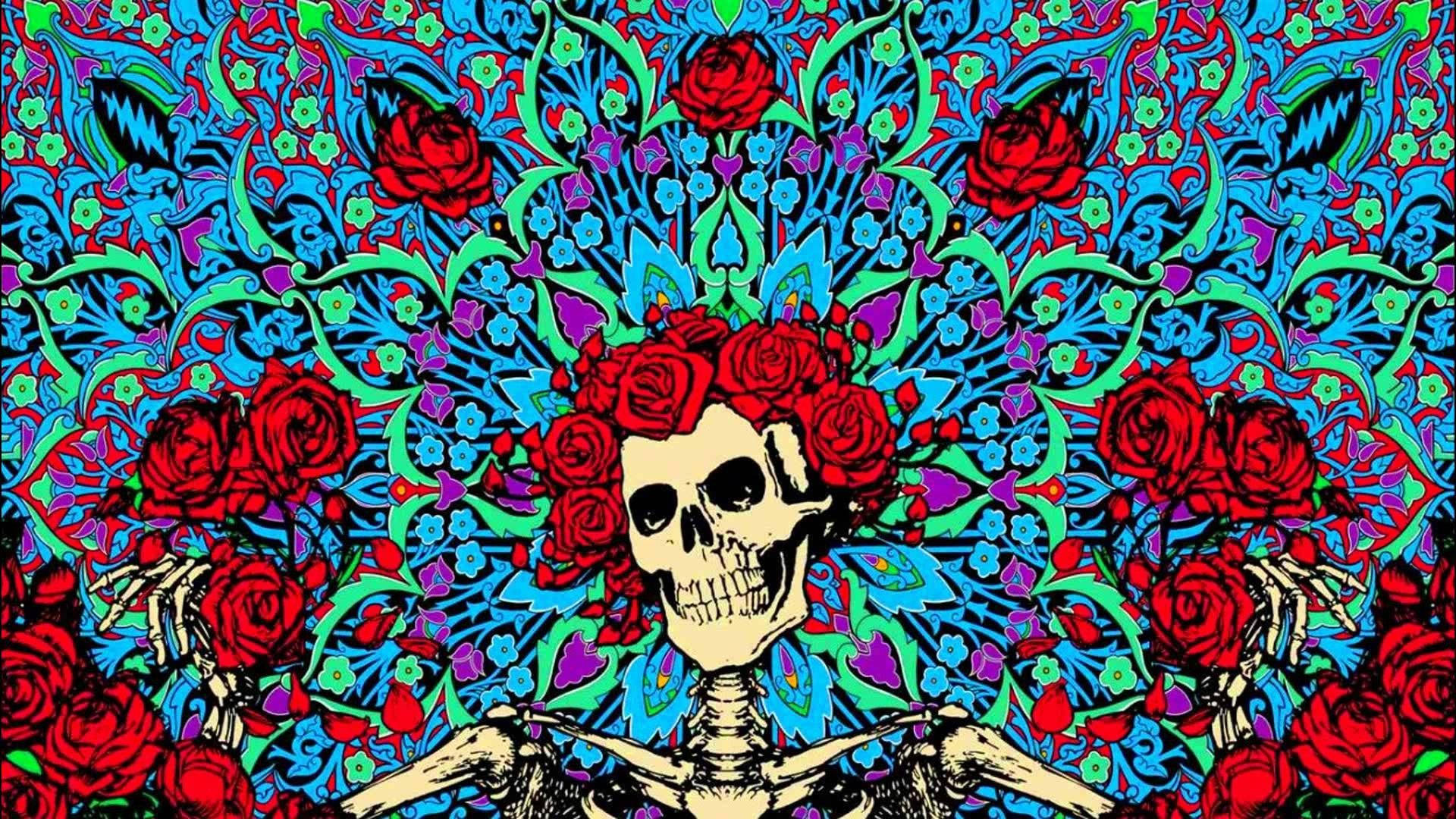 dead 桌布 壁紙 — 一個充滿活力的風格化骷髏，飾有紅玫瑰，從藍色、綠色和紫色的迷幻花卉圖案中浮現。