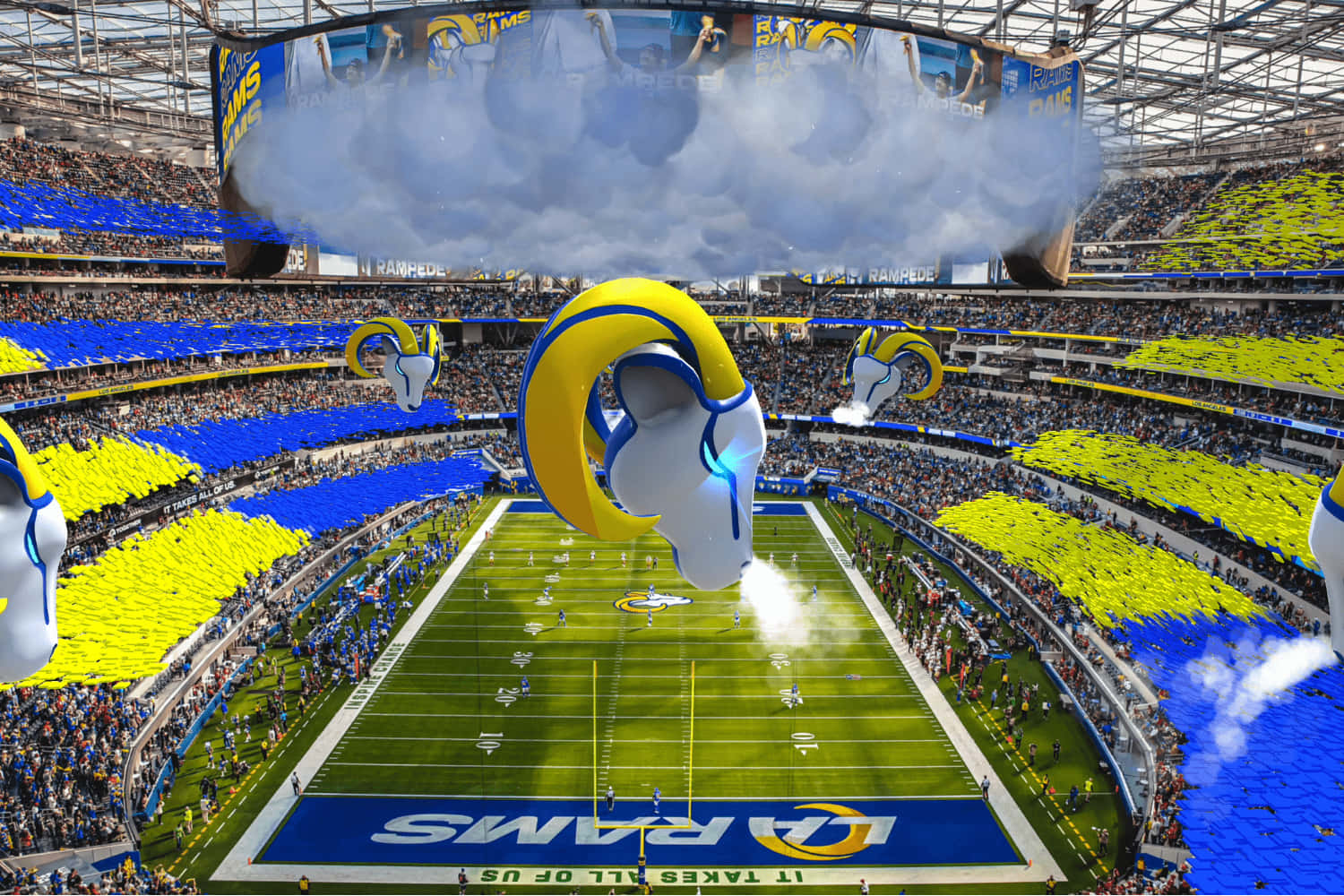 Sofi Stadium 桌布 壁紙 — 一個充滿活力的體育場，球迷揮舞著藍色和黃色的旗幟，巨大的公羊頭氣球漂浮在球場上方。