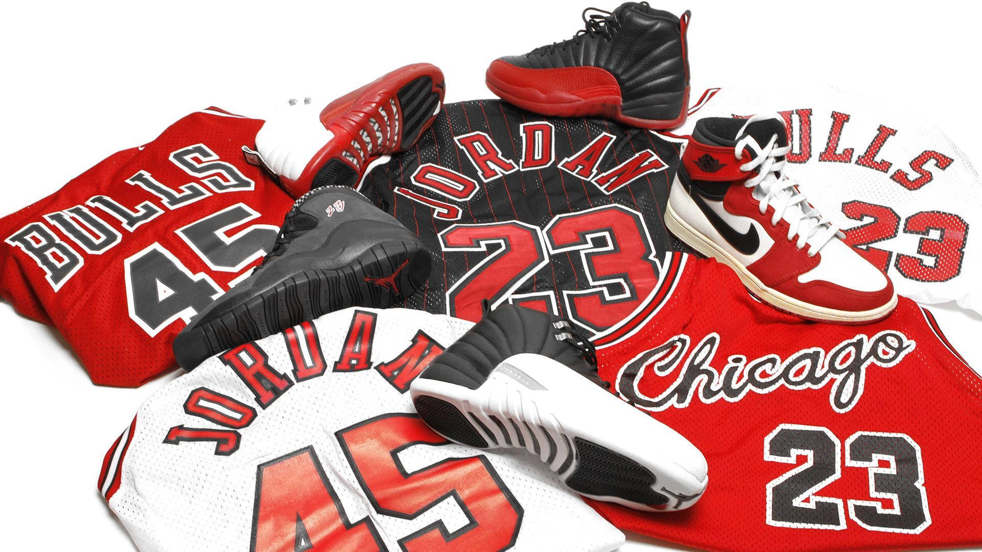 Jersey Numbers 桌布 壁紙 — 一個充滿活力的麥可喬丹紀念品系列，包括紅色和白色的芝加哥公牛隊球衣以及標誌性的 Air Jordan 運動鞋，整齊排列在潔白的背景上。