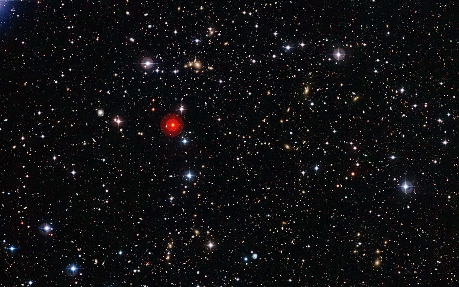 Stars 桌布 壁紙 — 一個充滿無數恆星和星系的深空視圖，以一顆明亮的紅色恆星在黑色虛空中閃耀為特色。