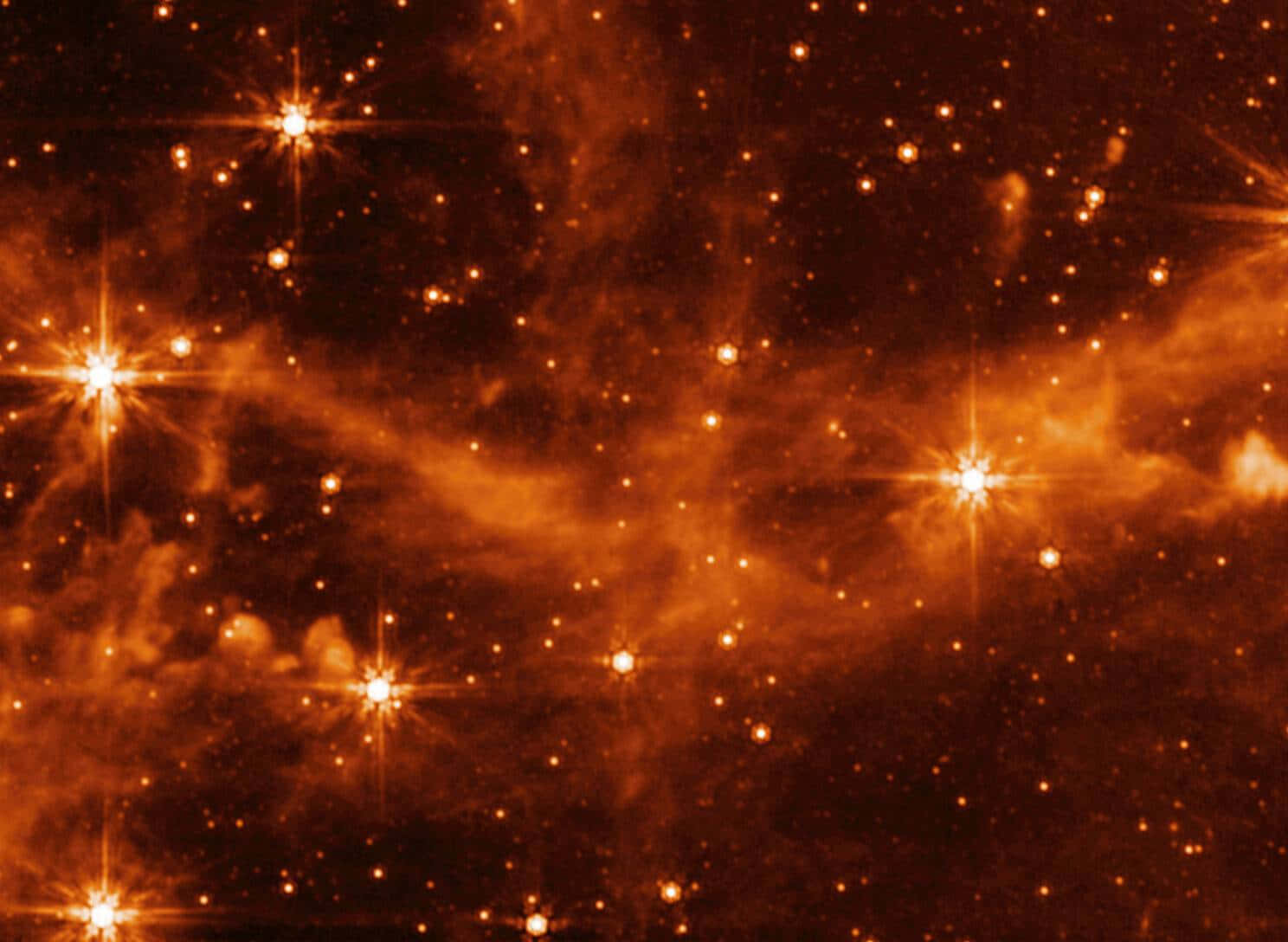 Stars 桌布 壁紙 — 一個充滿發光恆星和宇宙塵埃的鮮豔橙色星雲在深空中旋轉。