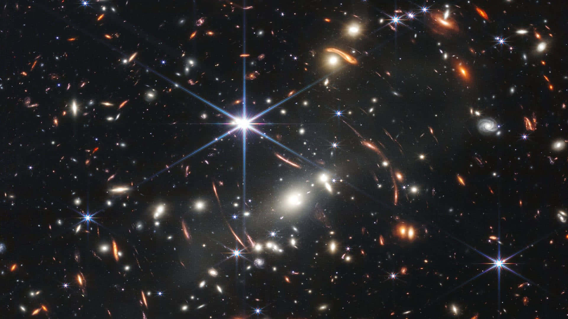 Universal 桌布 壁紙 — 一個充滿發光星系和璀璨恆星的宇宙景觀，背景是深邃的黑色虛空。